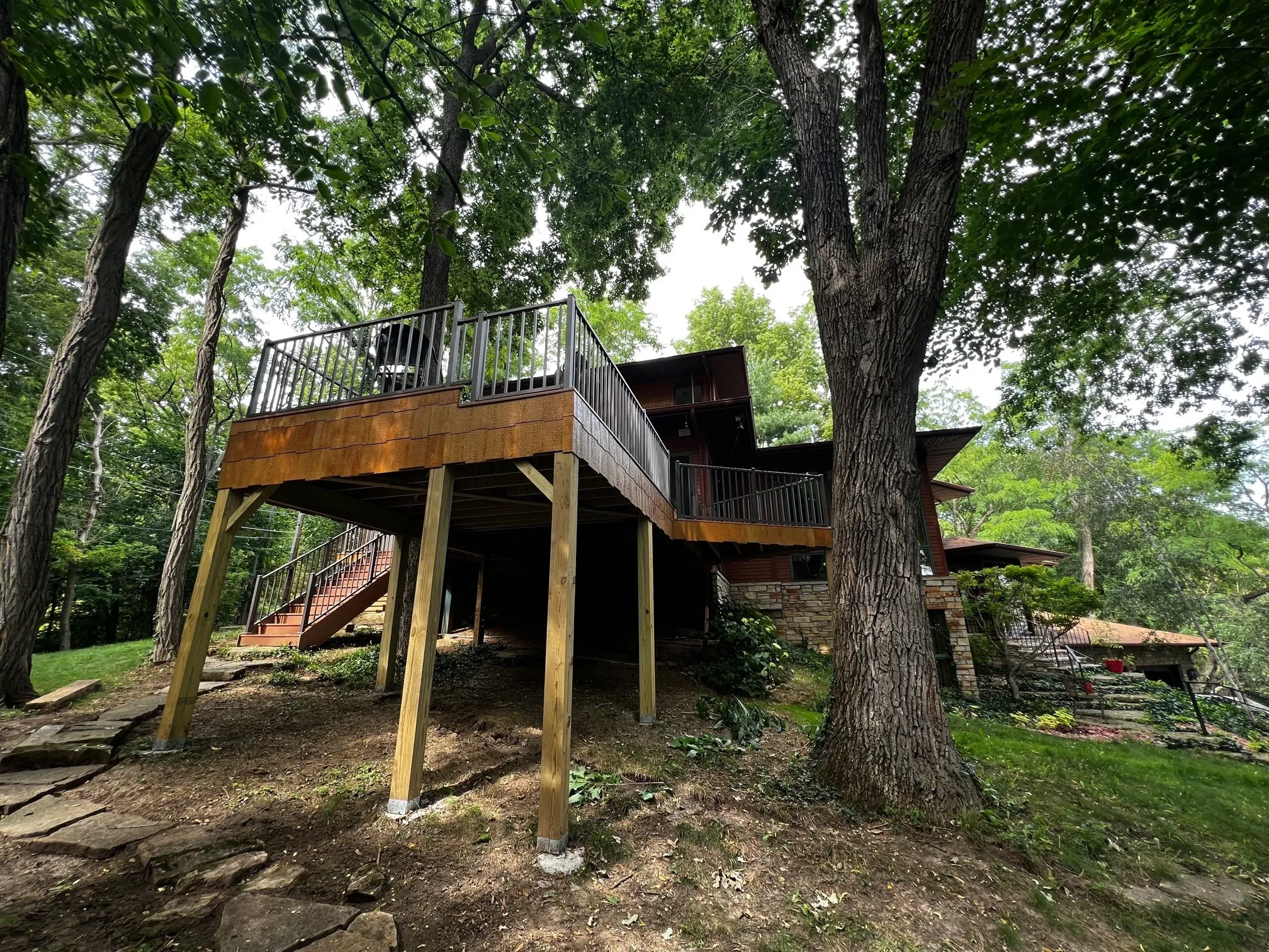 Angled deck and stair runs descending the wooded slope