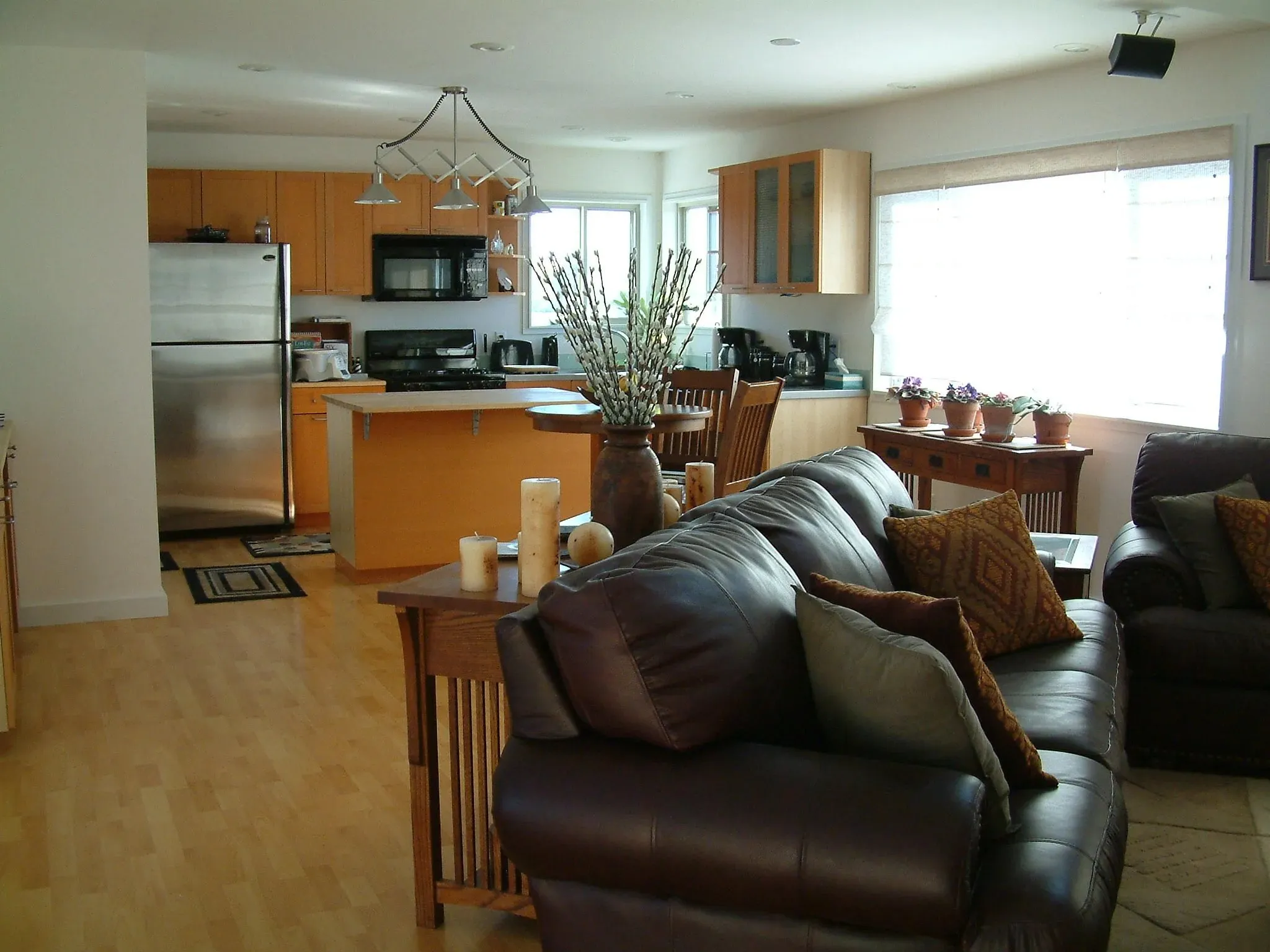 Open kitchen and living area with maple cabinetry and island