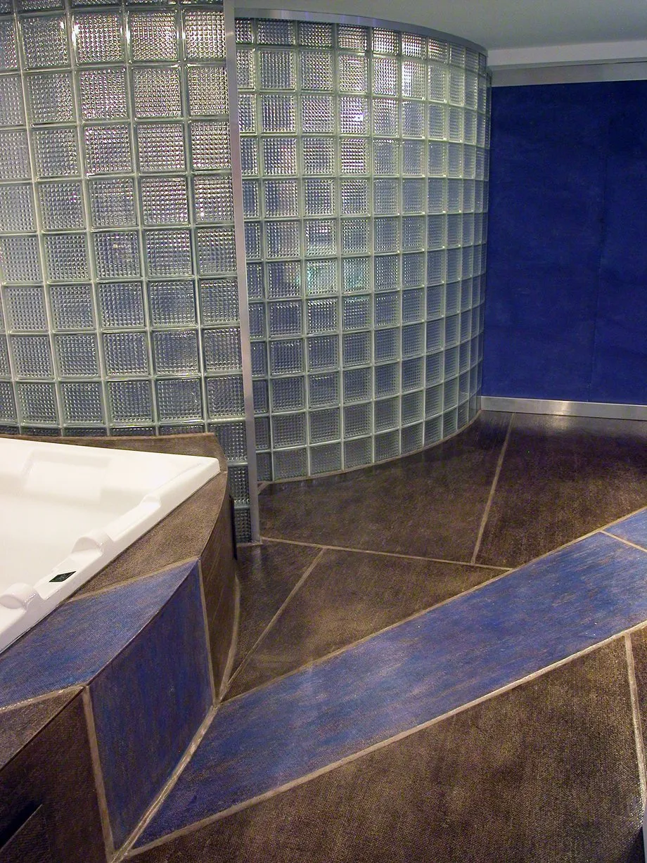Glass block shower wall and diagonal tile in a lower-level bath