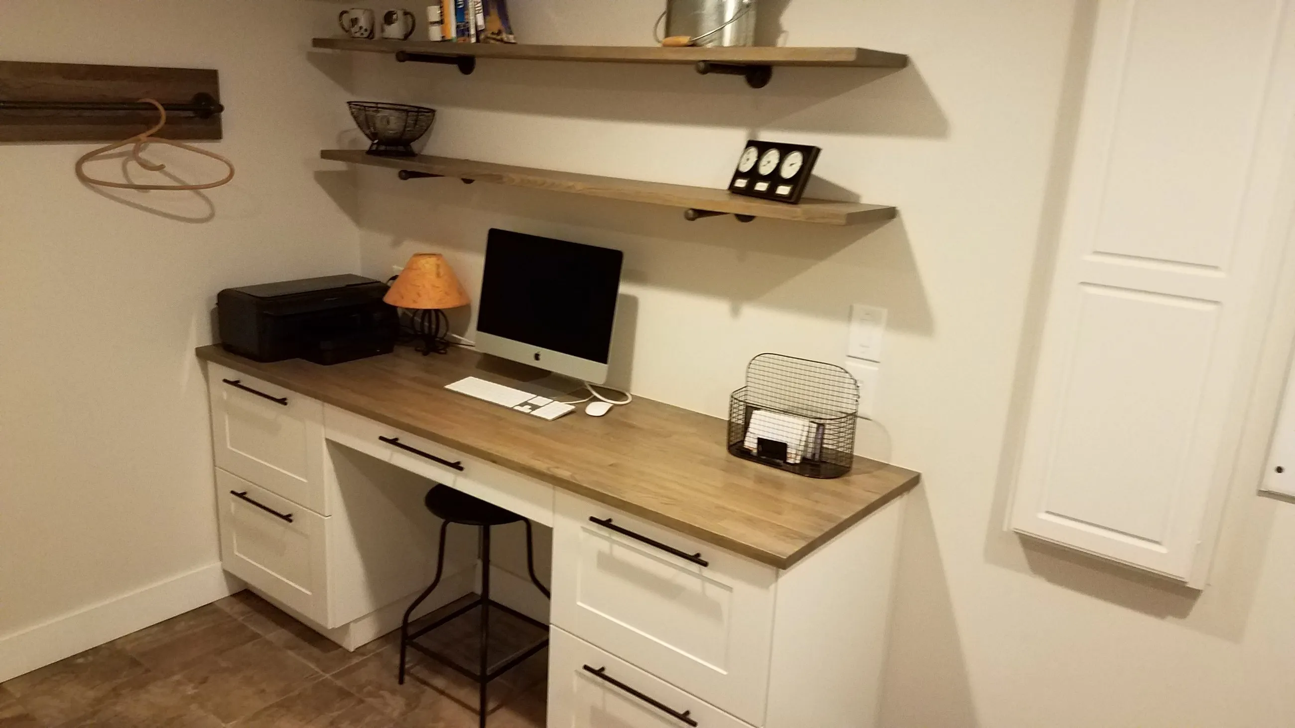 Lower-level laundry and workspace with butcher block counters and open pipe-bracket shelving