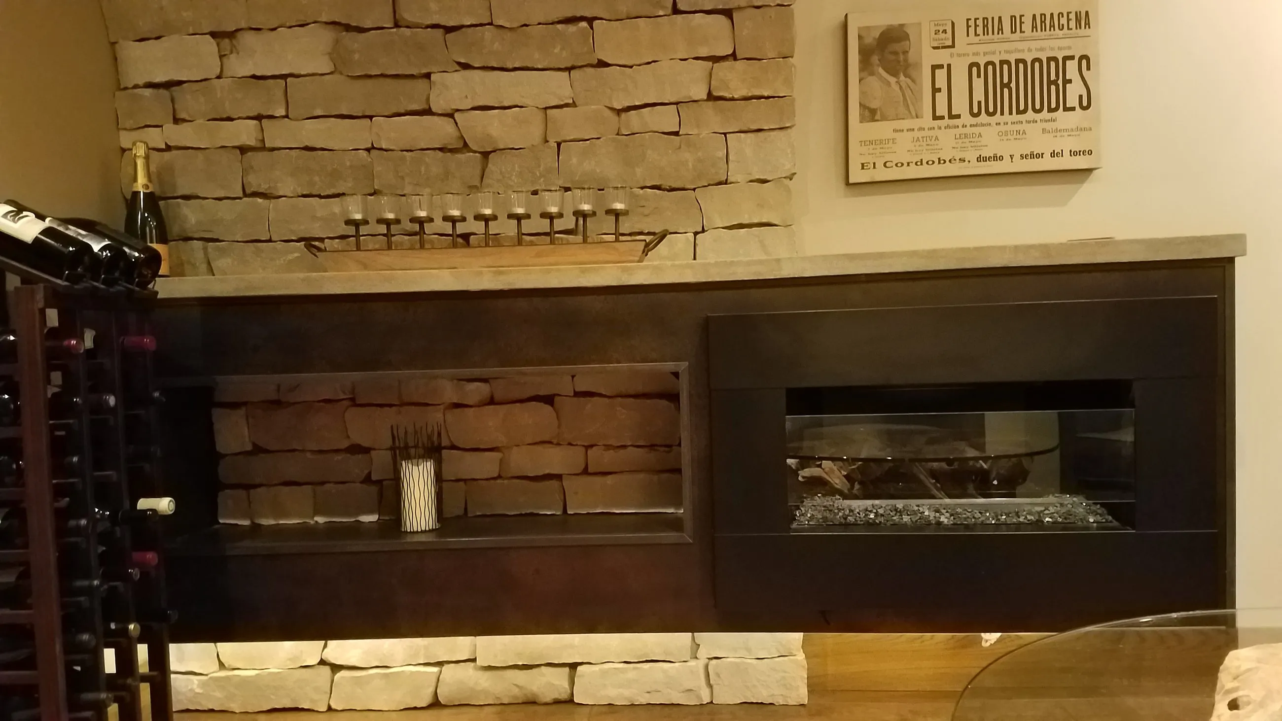 Linear fireplace set into a dry-stacked stone wall of a lower-level lounge