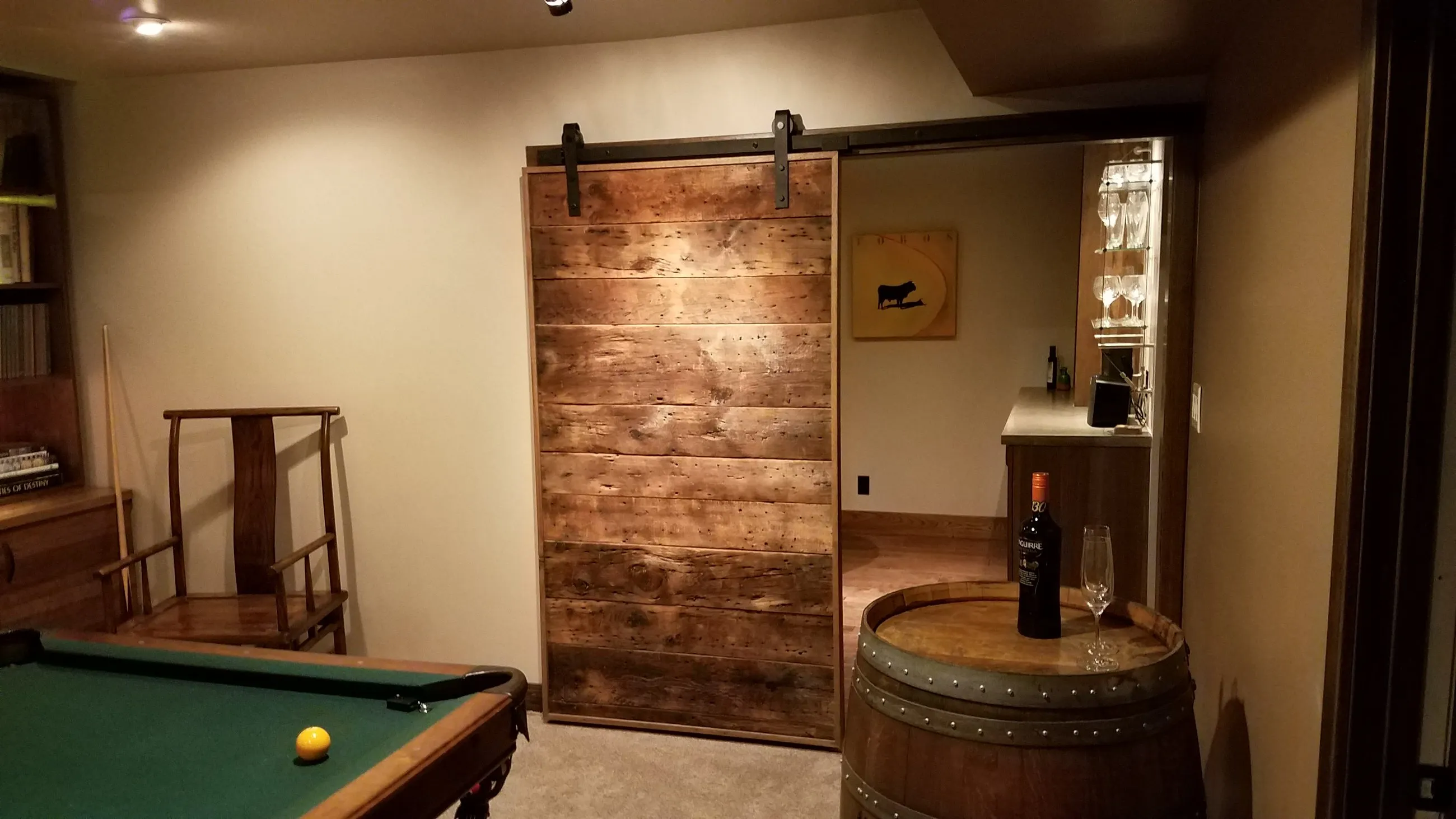 Sliding plank barn door off a basement billiards room