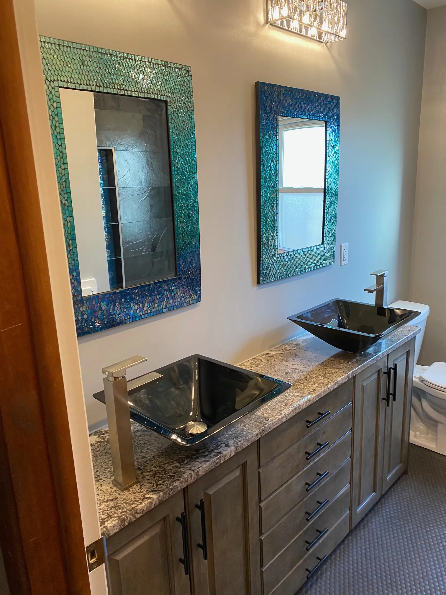 Teal mosaic mirrors with dark glass vessel sinks