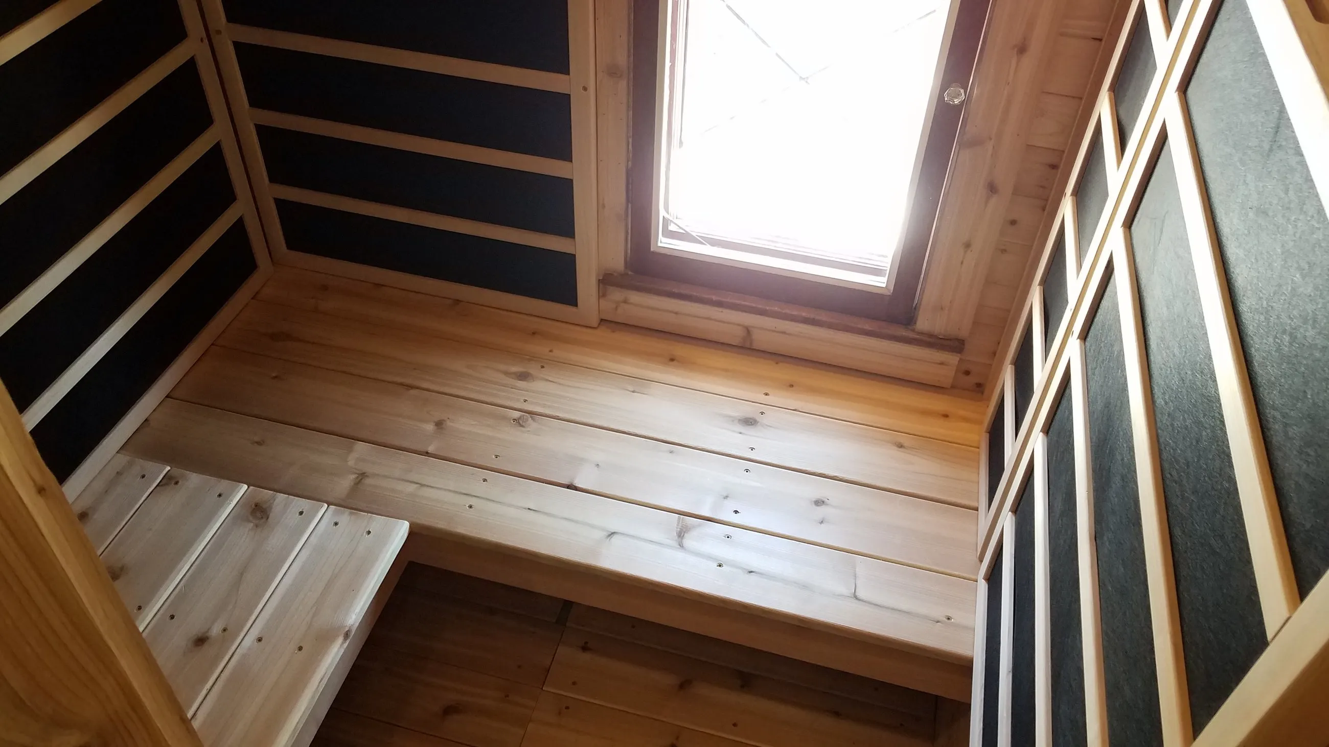 Cedar sauna with tiered benches and wall heaters