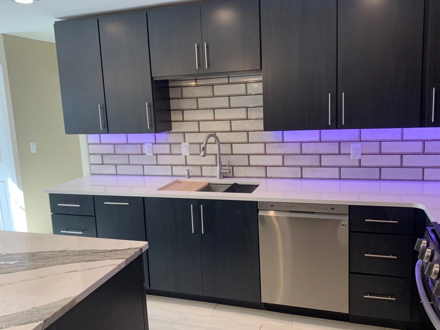 Sink wall with white subway tile and under-cabinet lighting