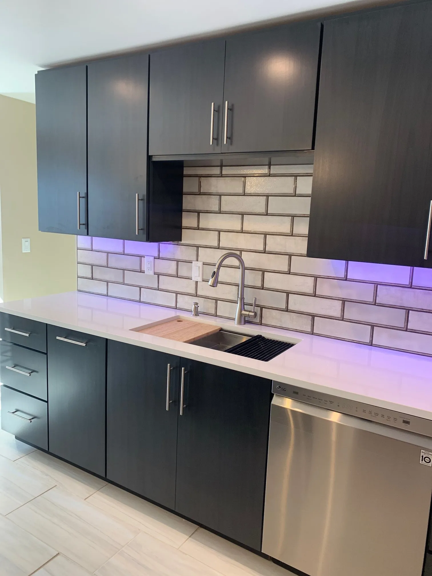 Sink run with lit subway backsplash and stainless dishwasher