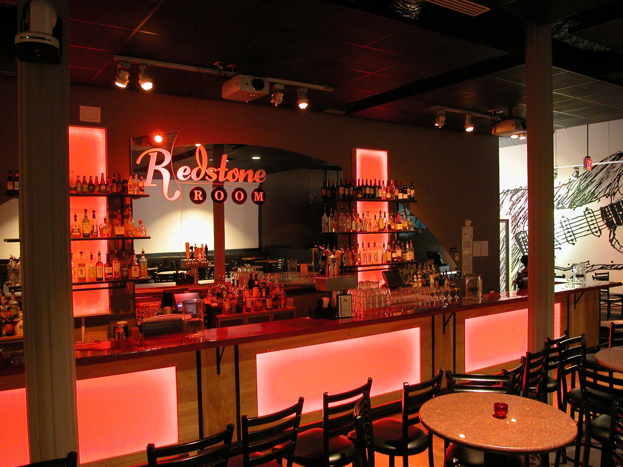 Backlit bar with illuminated liquor display in a live music venue build-out