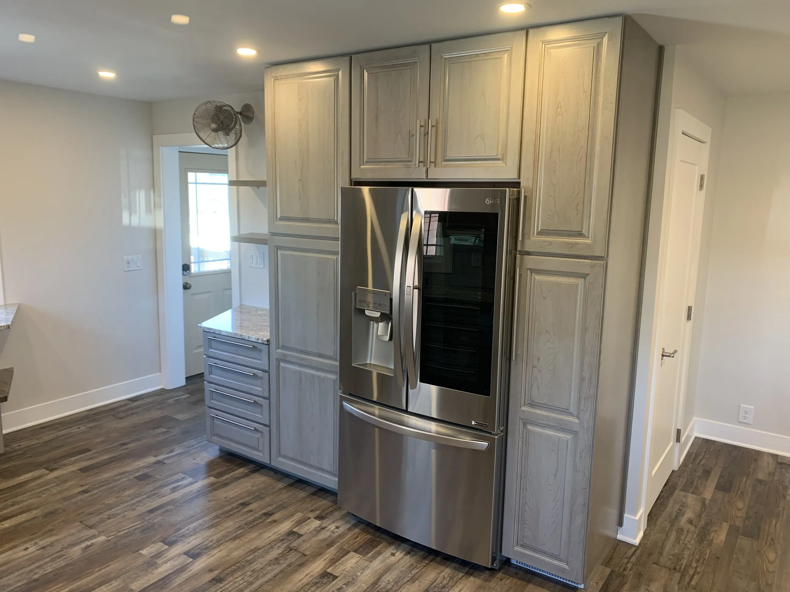 Tall grey-washed pantry run around the refrigerator