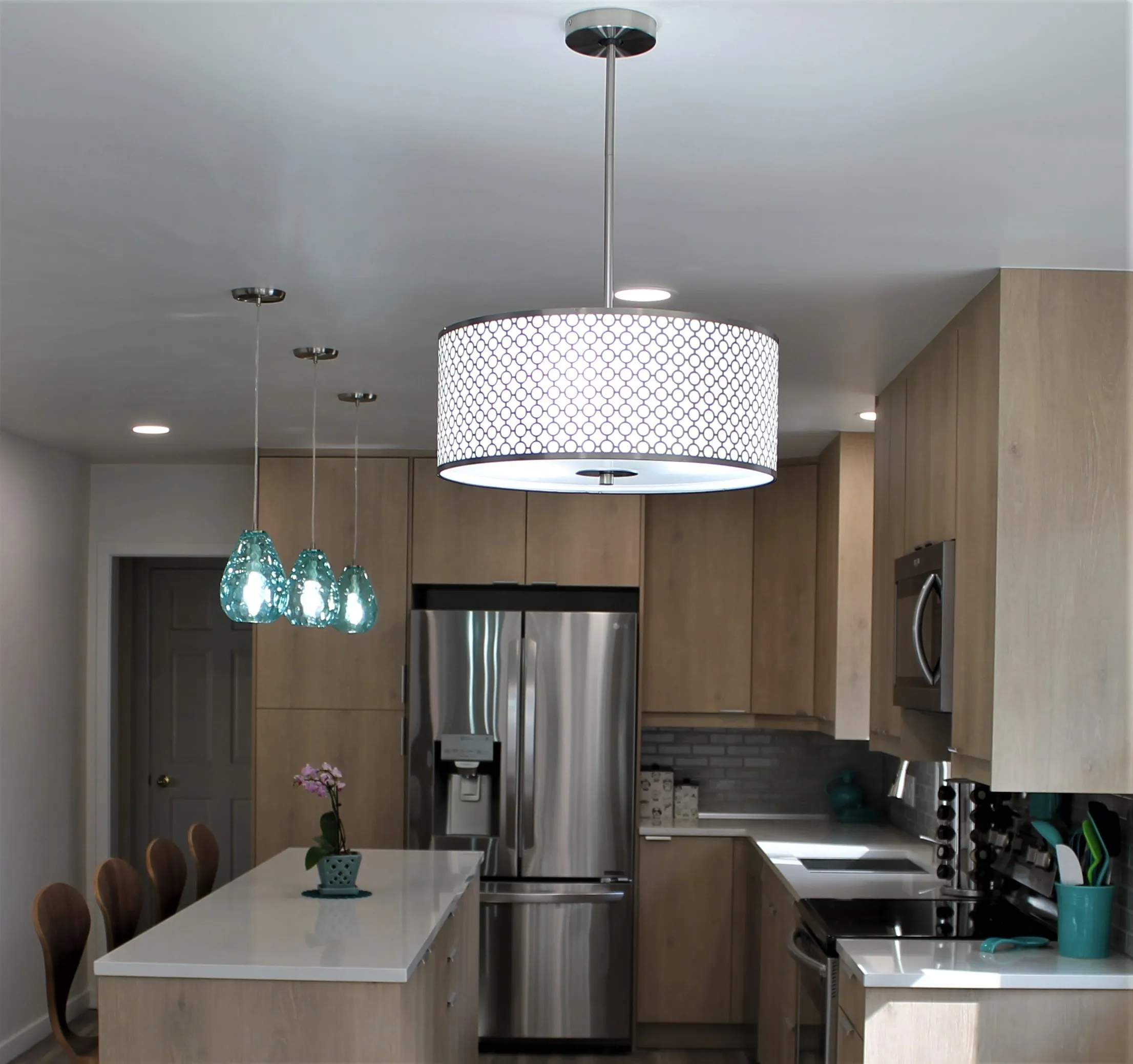Light wood kitchen with aqua glass pendants