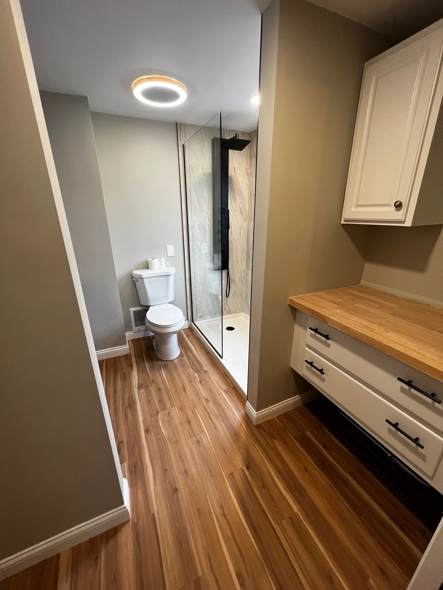 White storage cabinetry and wood counter in the master bath