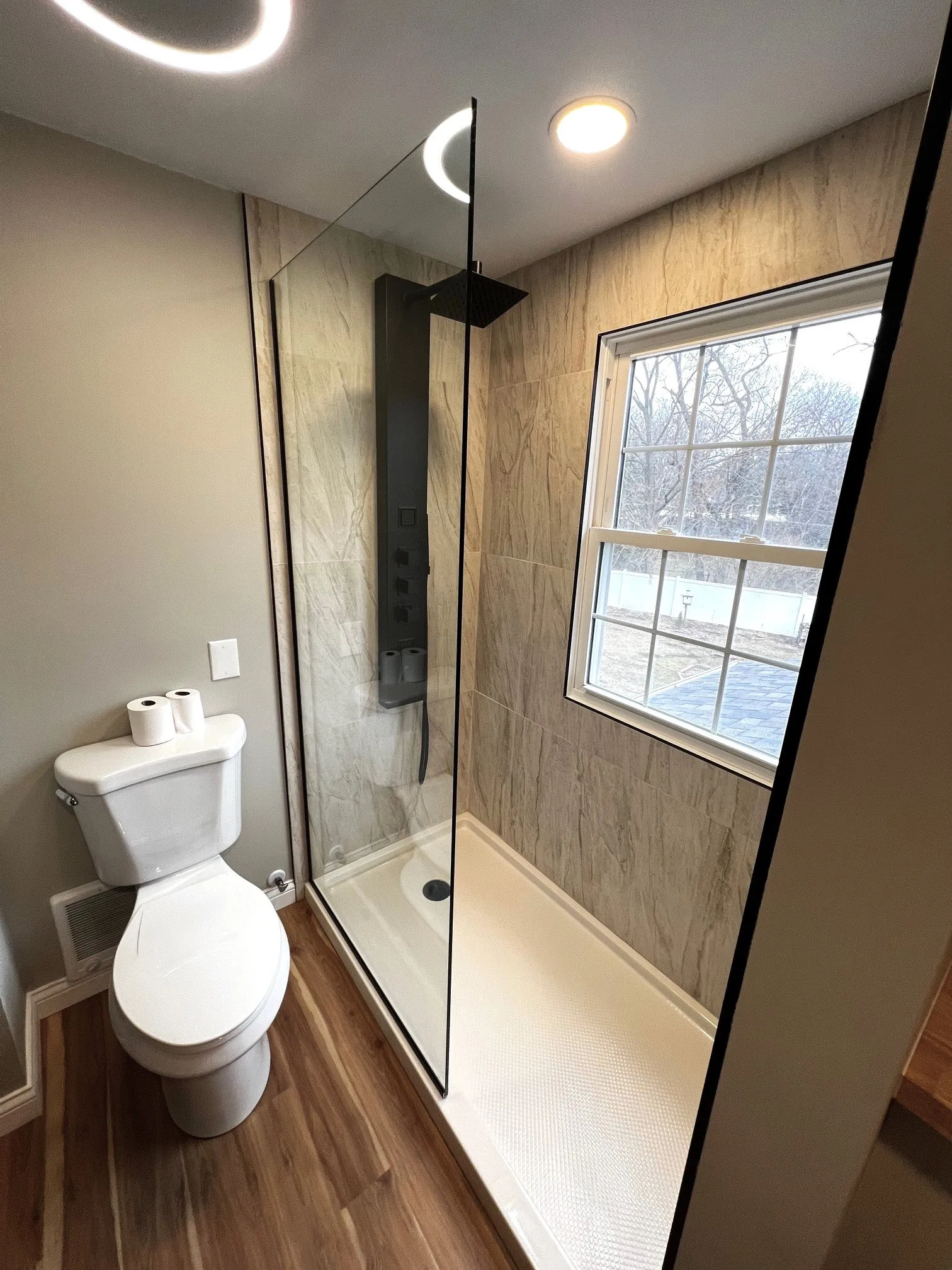 Glass shower panel beside the window