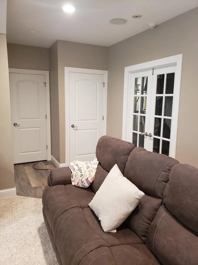 Sofa beside white doors, trimmed to match the main floor