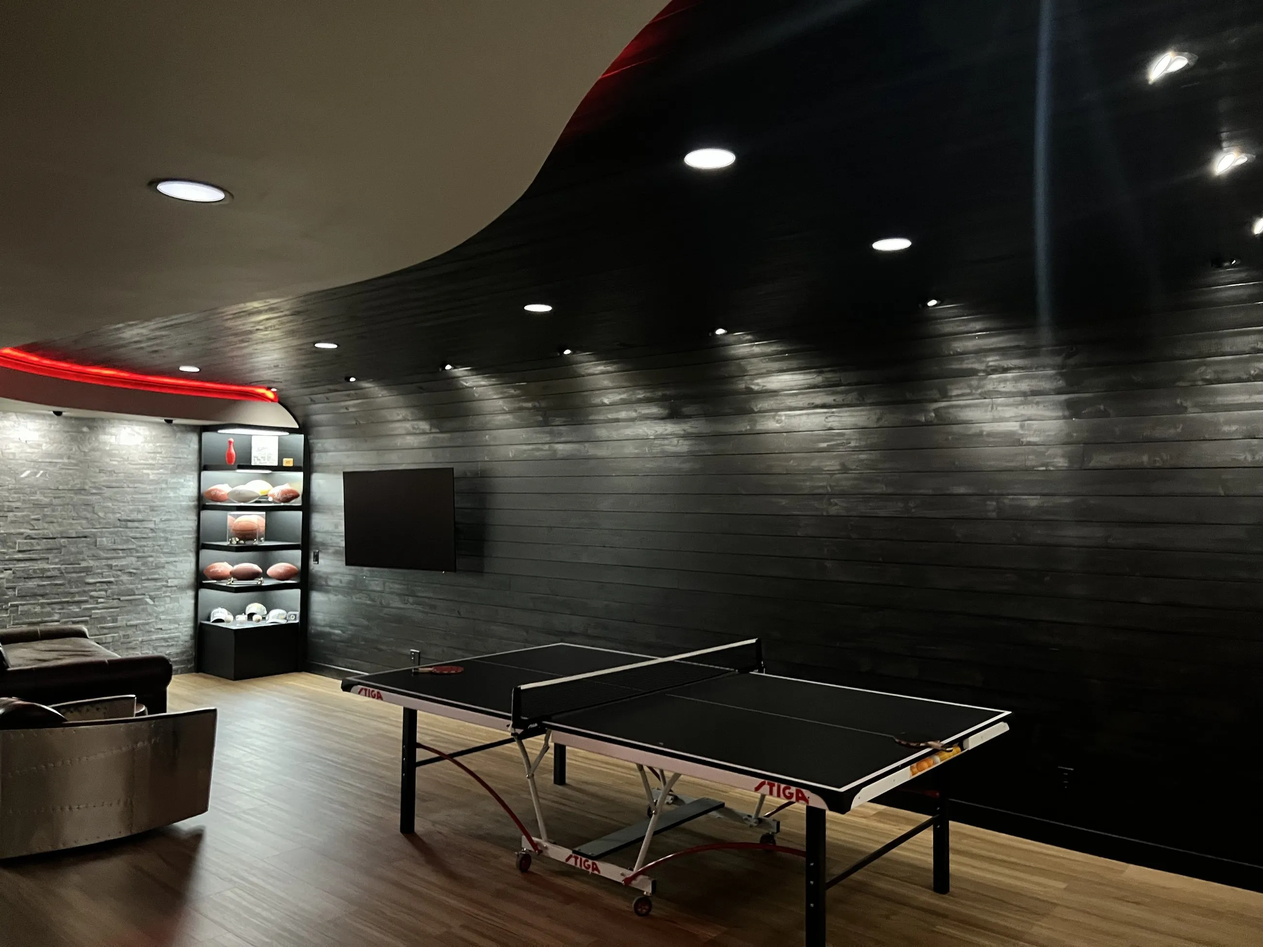 Black wood feature wall curving over the games area
