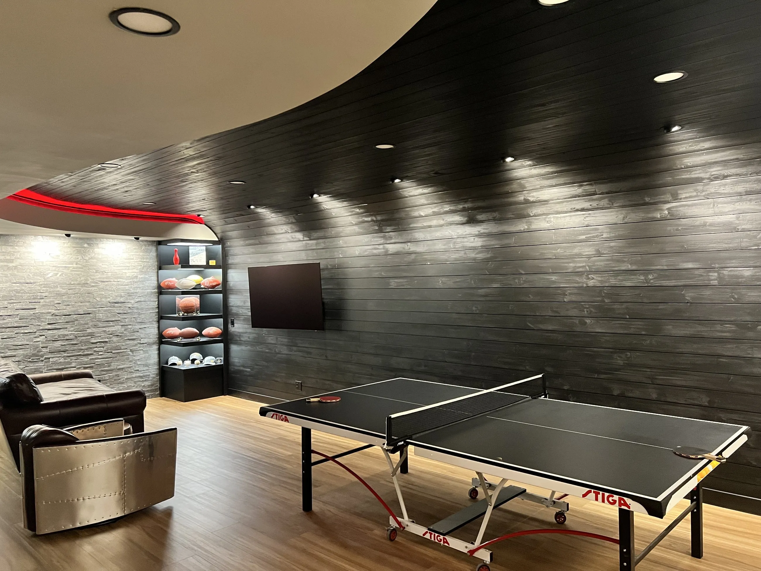 Leather seating and screen along the dark feature wall