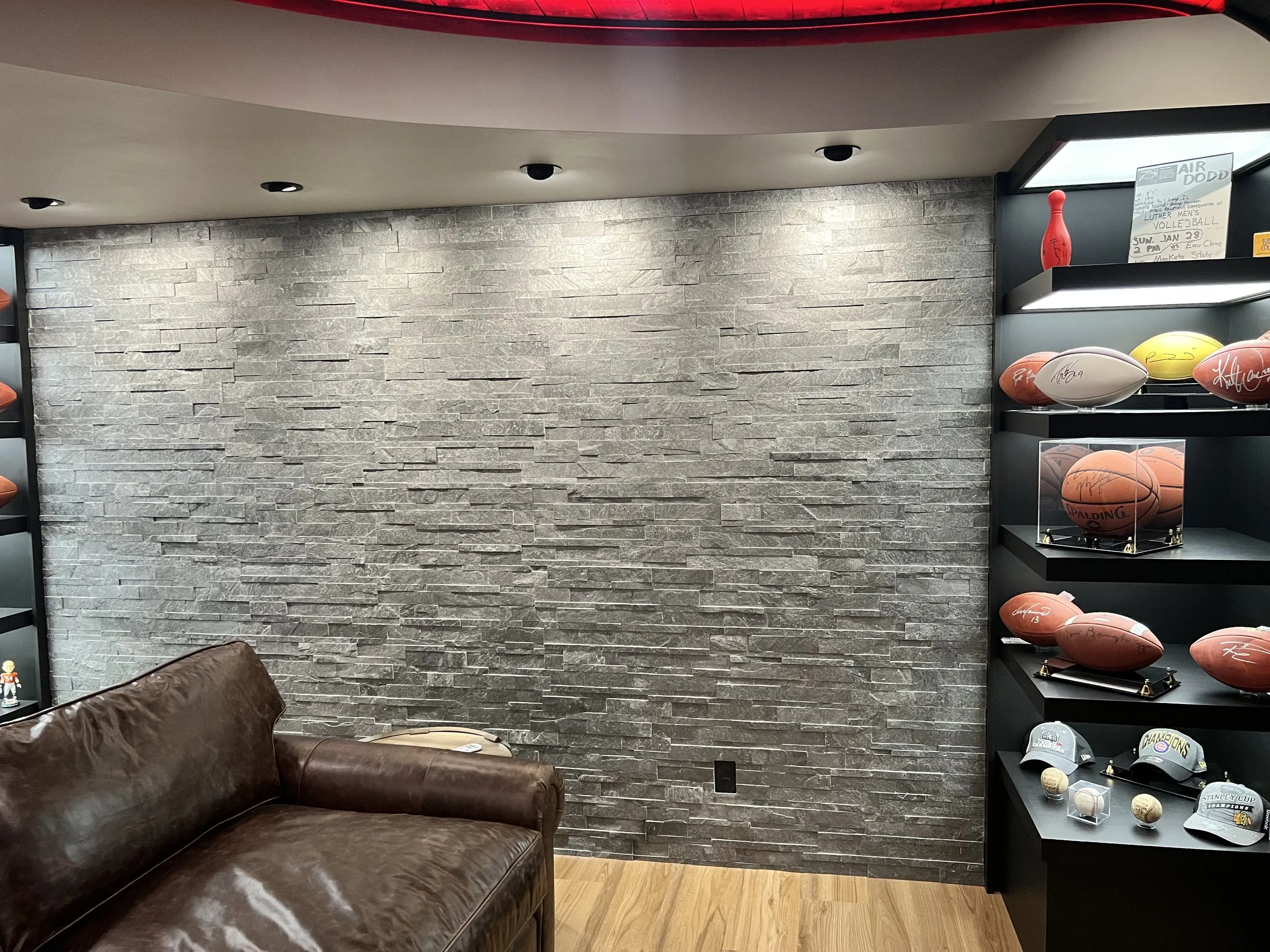 Stacked stone wall with display shelving and leather sofa