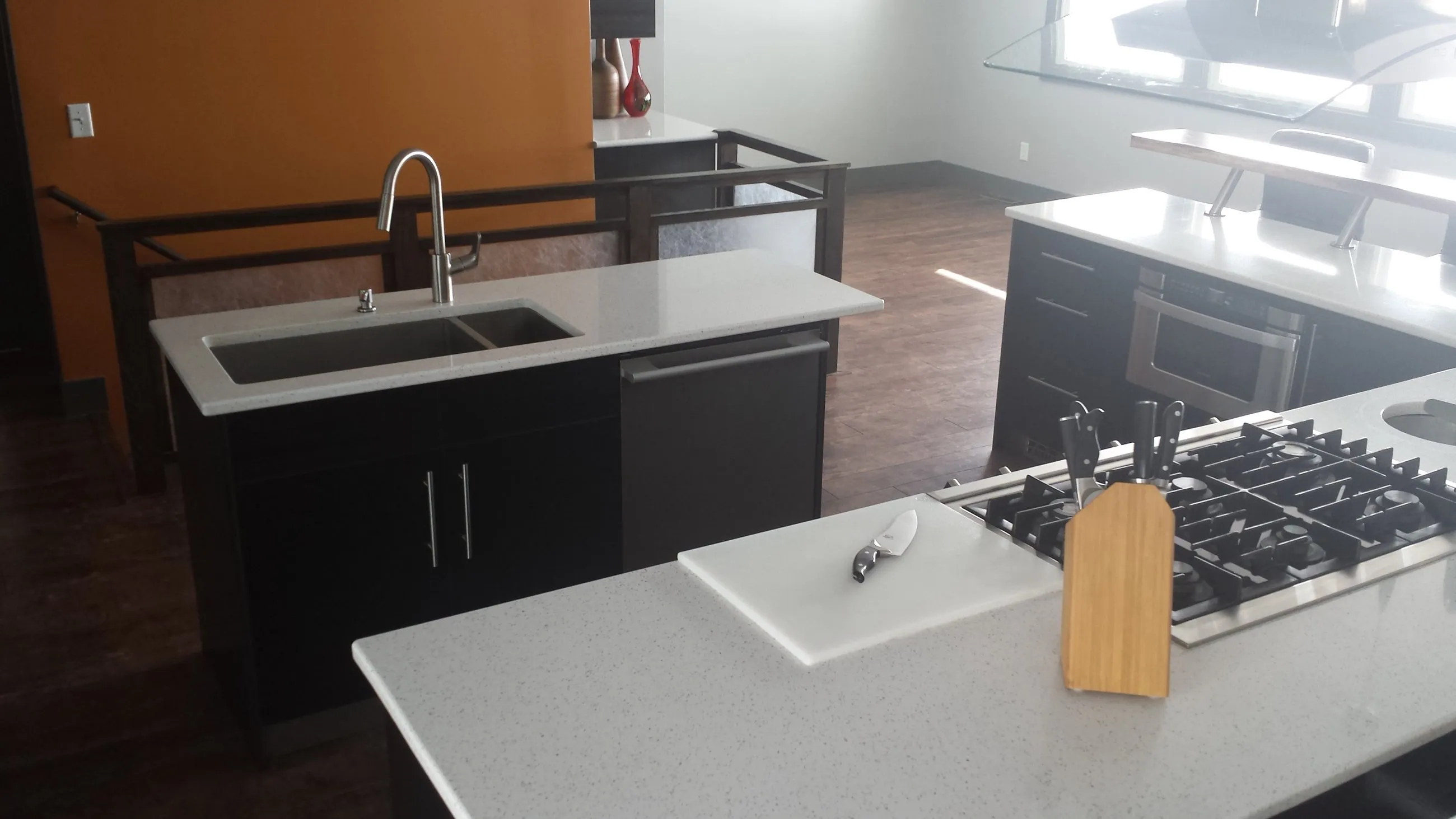 Prep island with cooktop, sink, and cutting board