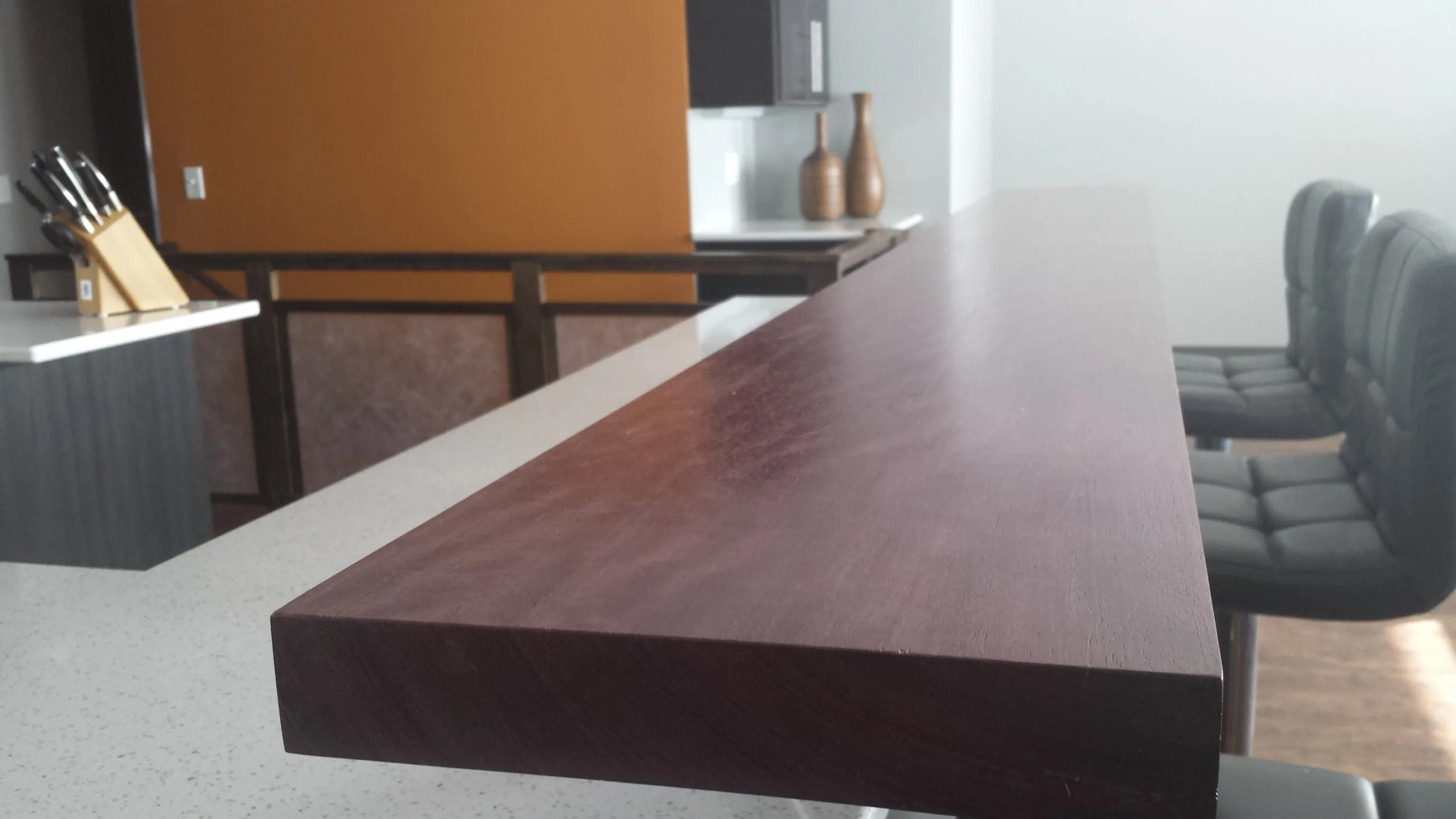 Dark red bar top cantilevered over the island