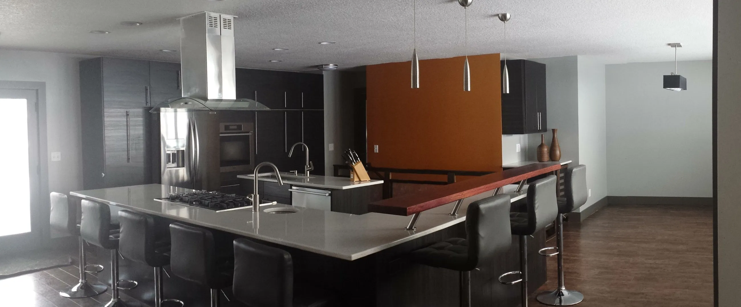 Wide view of the open kitchen and orange accent wall
