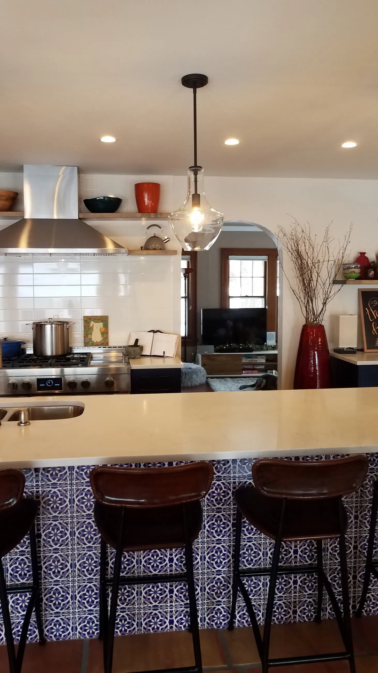 Island sink with white counter over Moroccan tile