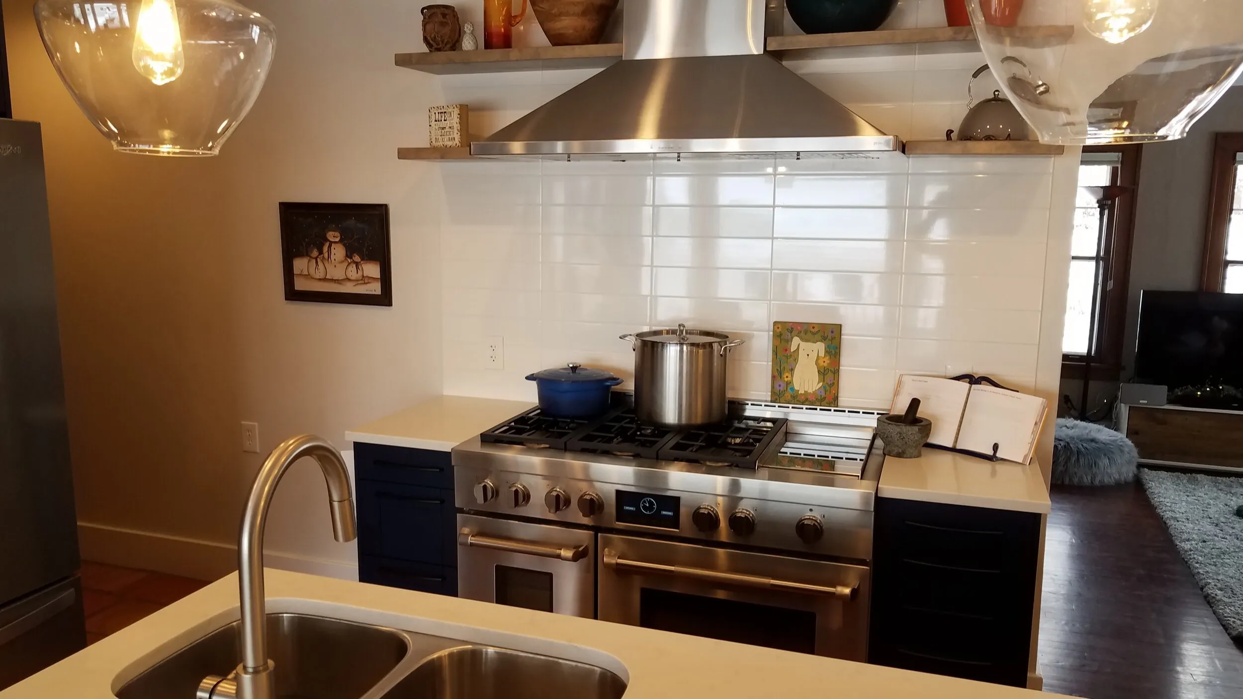 Stainless range and hood between navy cabinets