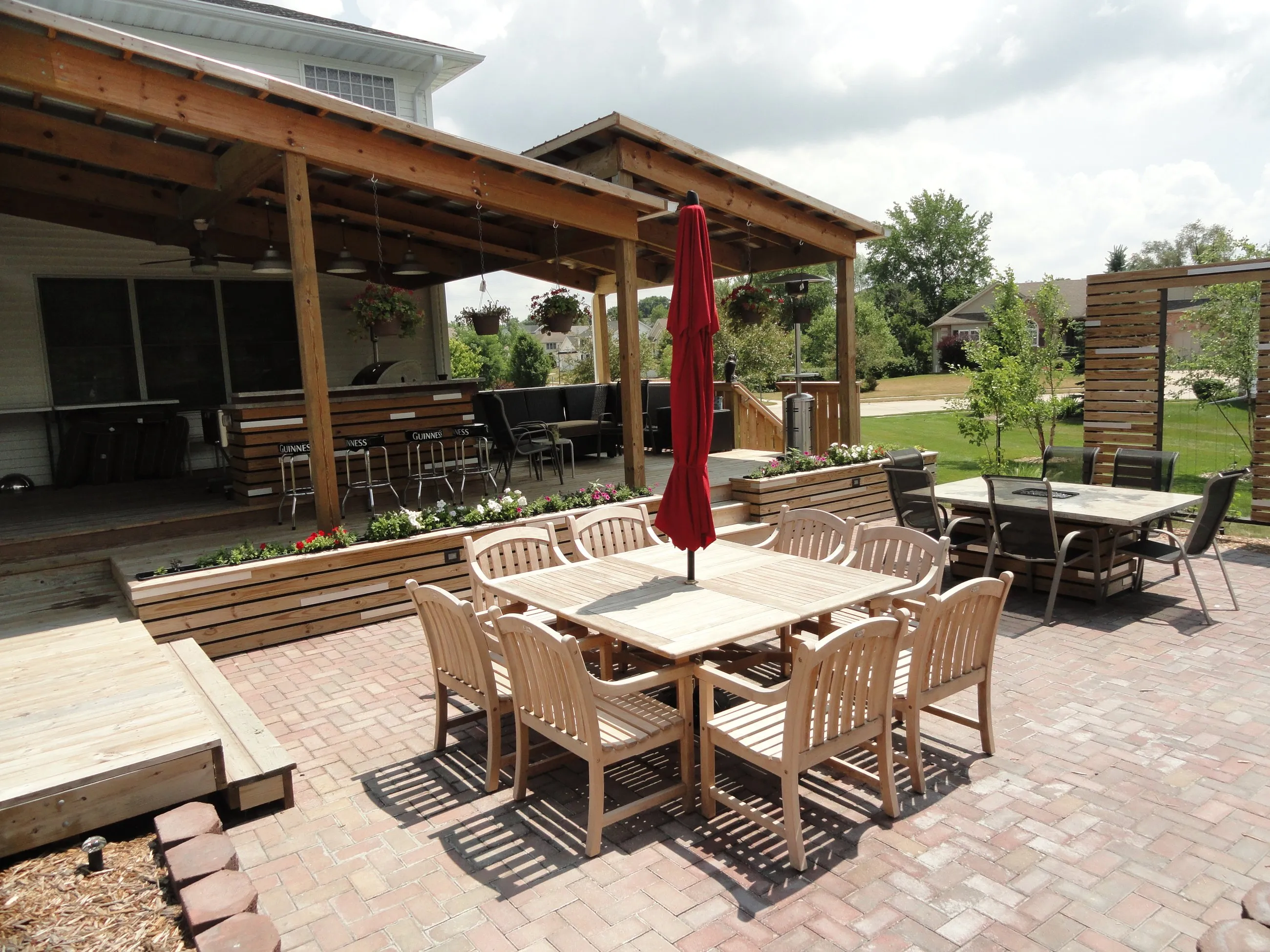 Paver patio with a wood dining set under a timber pergola