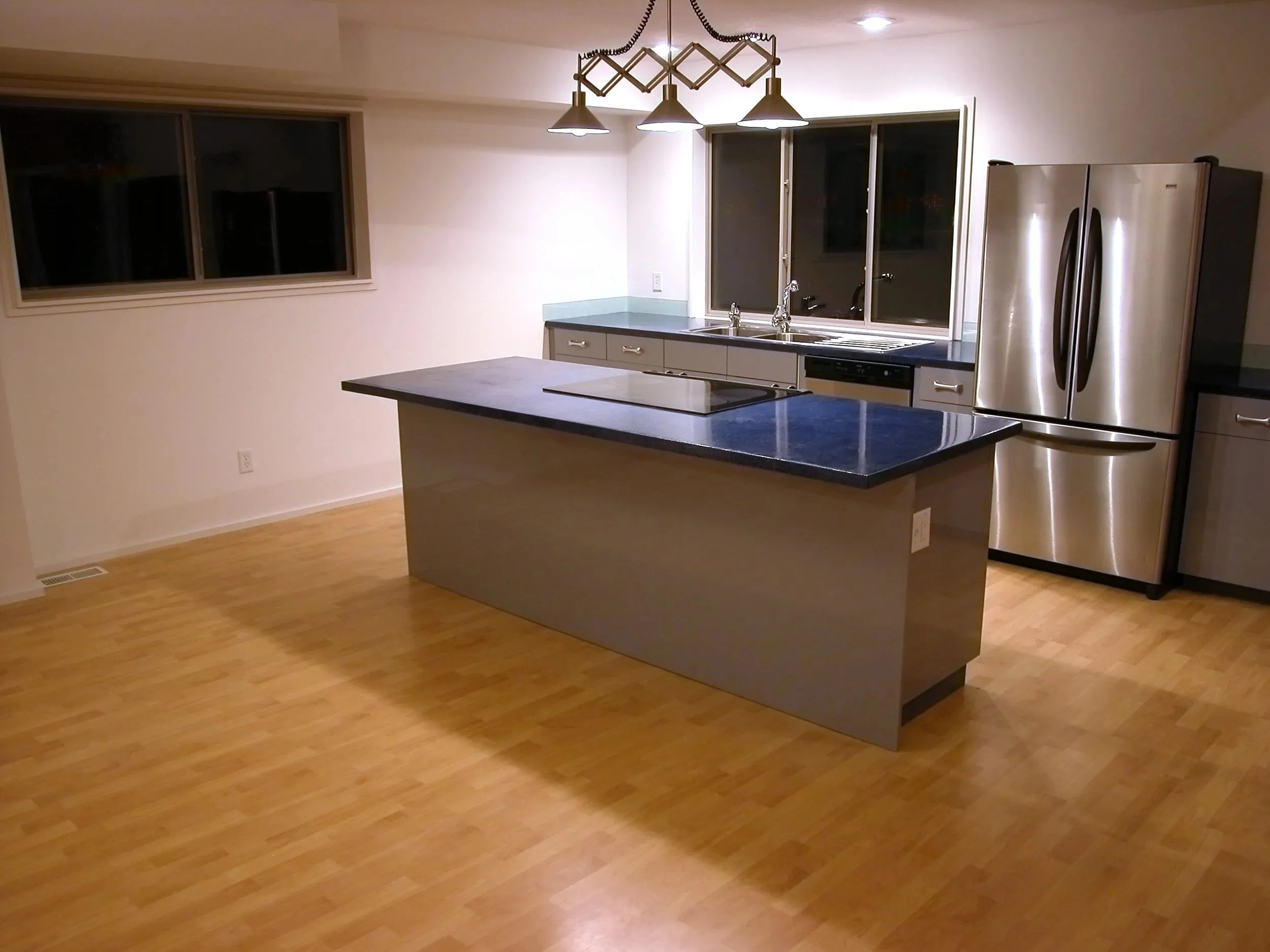 Deep blue island with pendant lighting in the open kitchen
