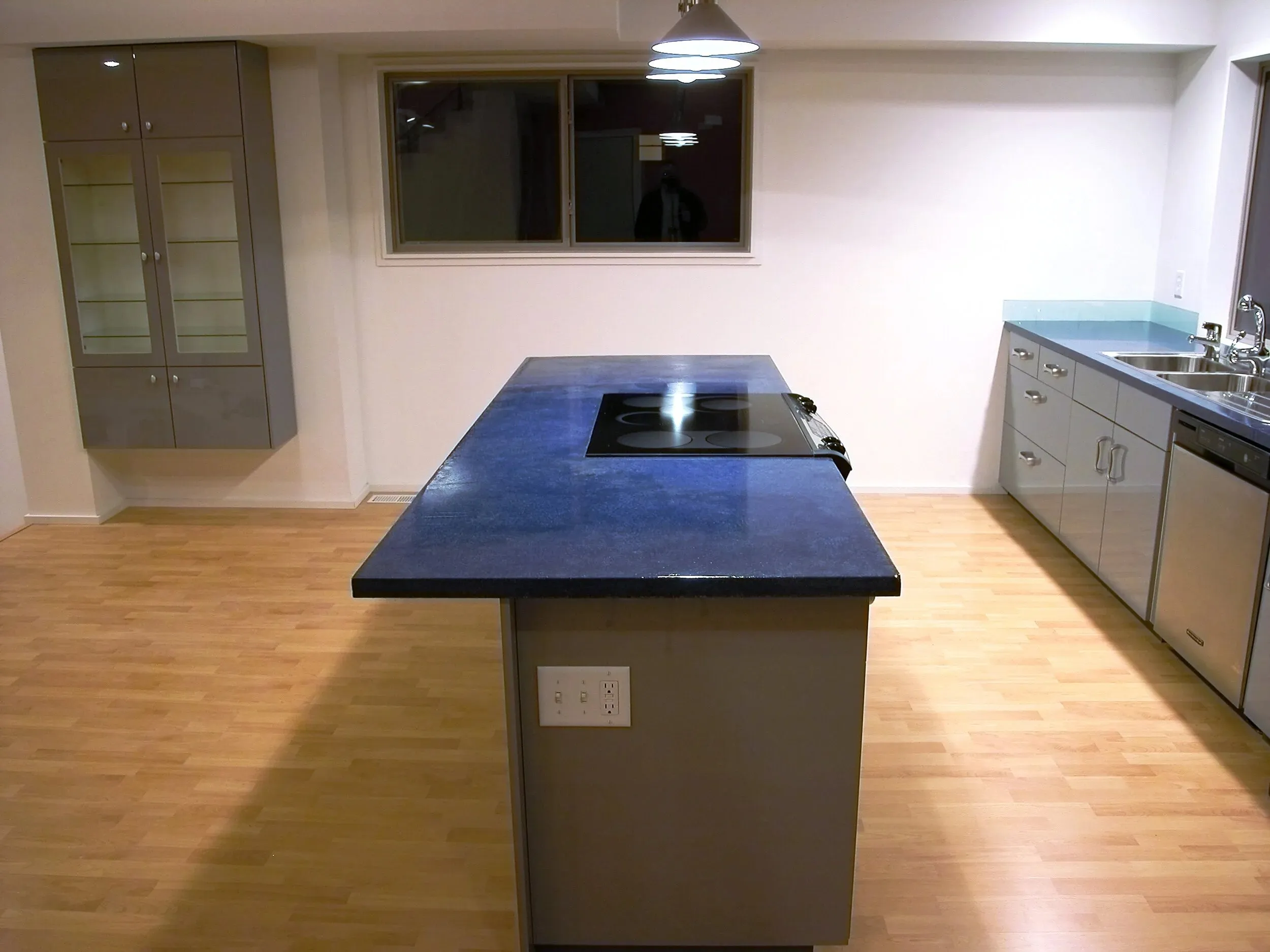 Deep blue island against grey cabinetry and stainless appliances