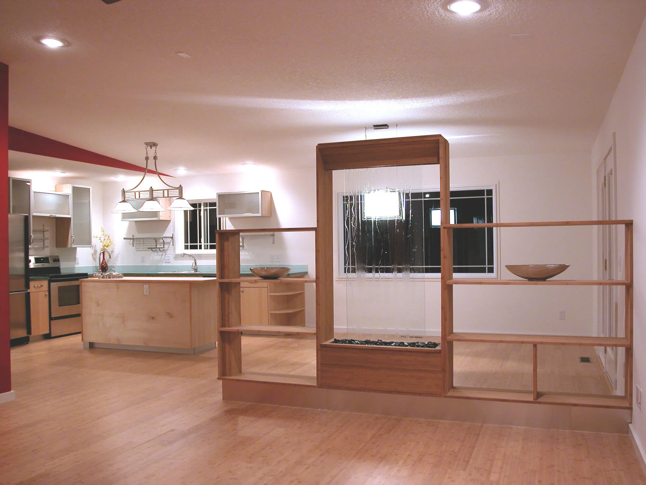 Light wood room divider and open shelving by the kitchen