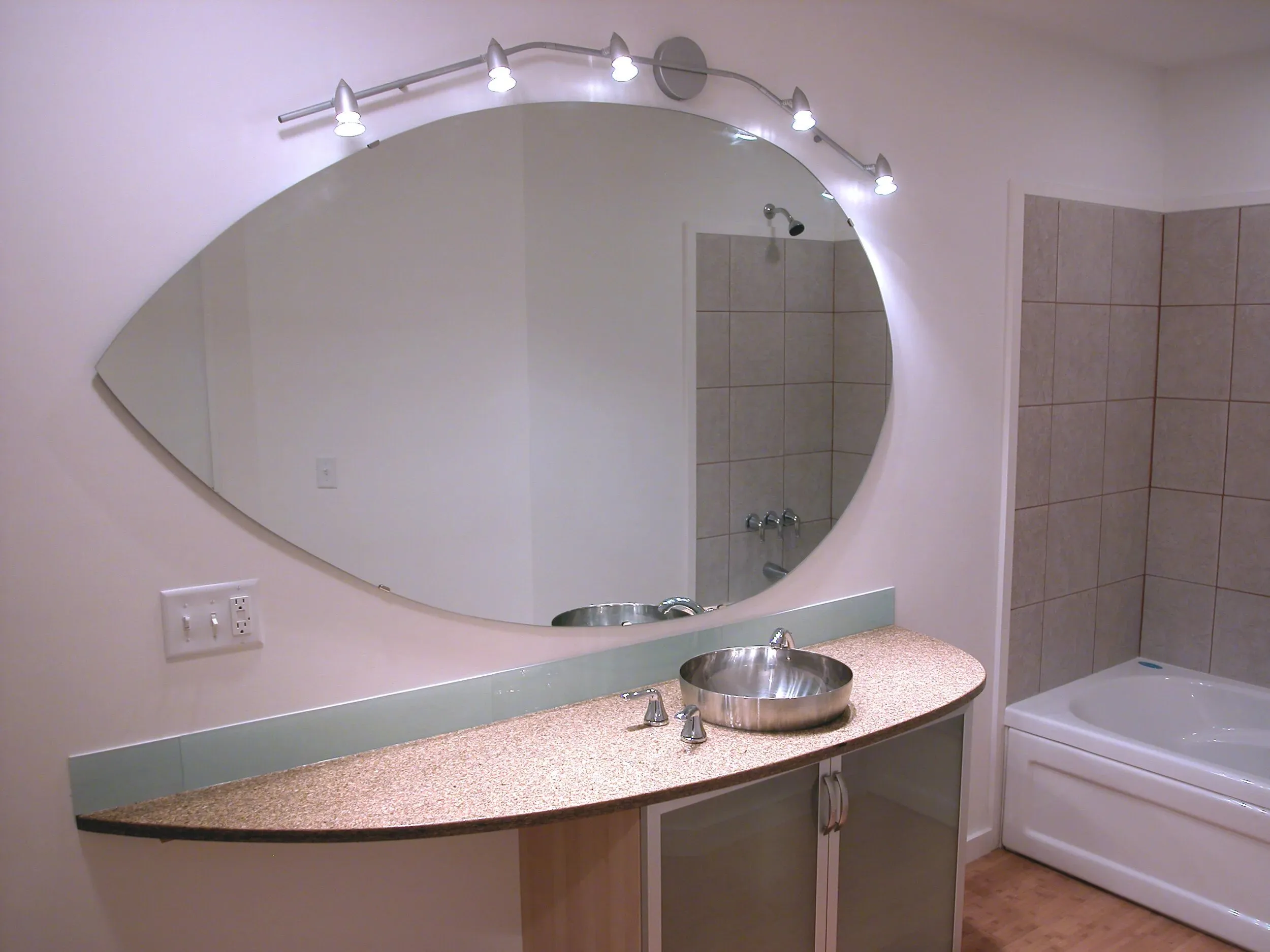 Master bath vanity with oval mirror and curved counter