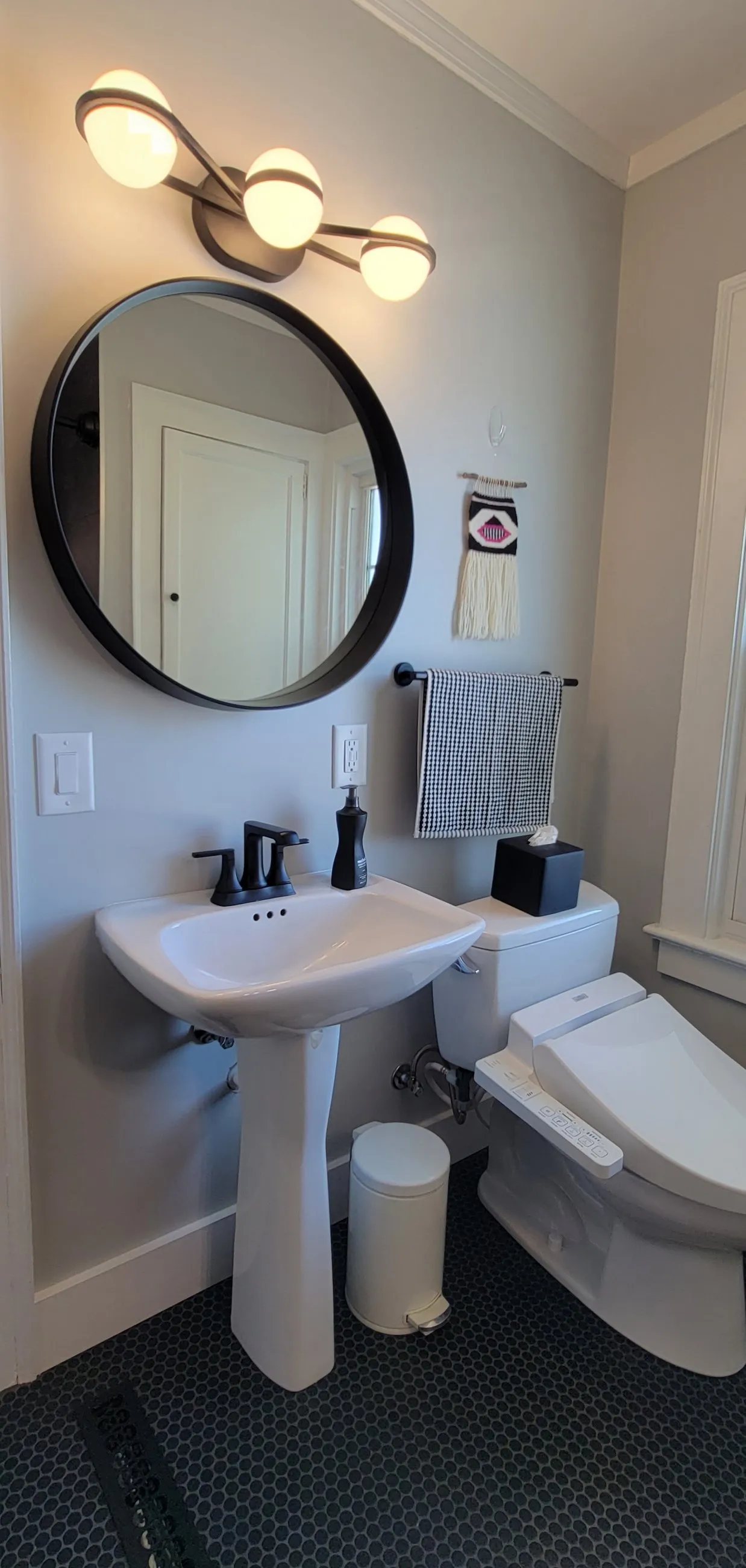 Round mirror over the pedestal sink