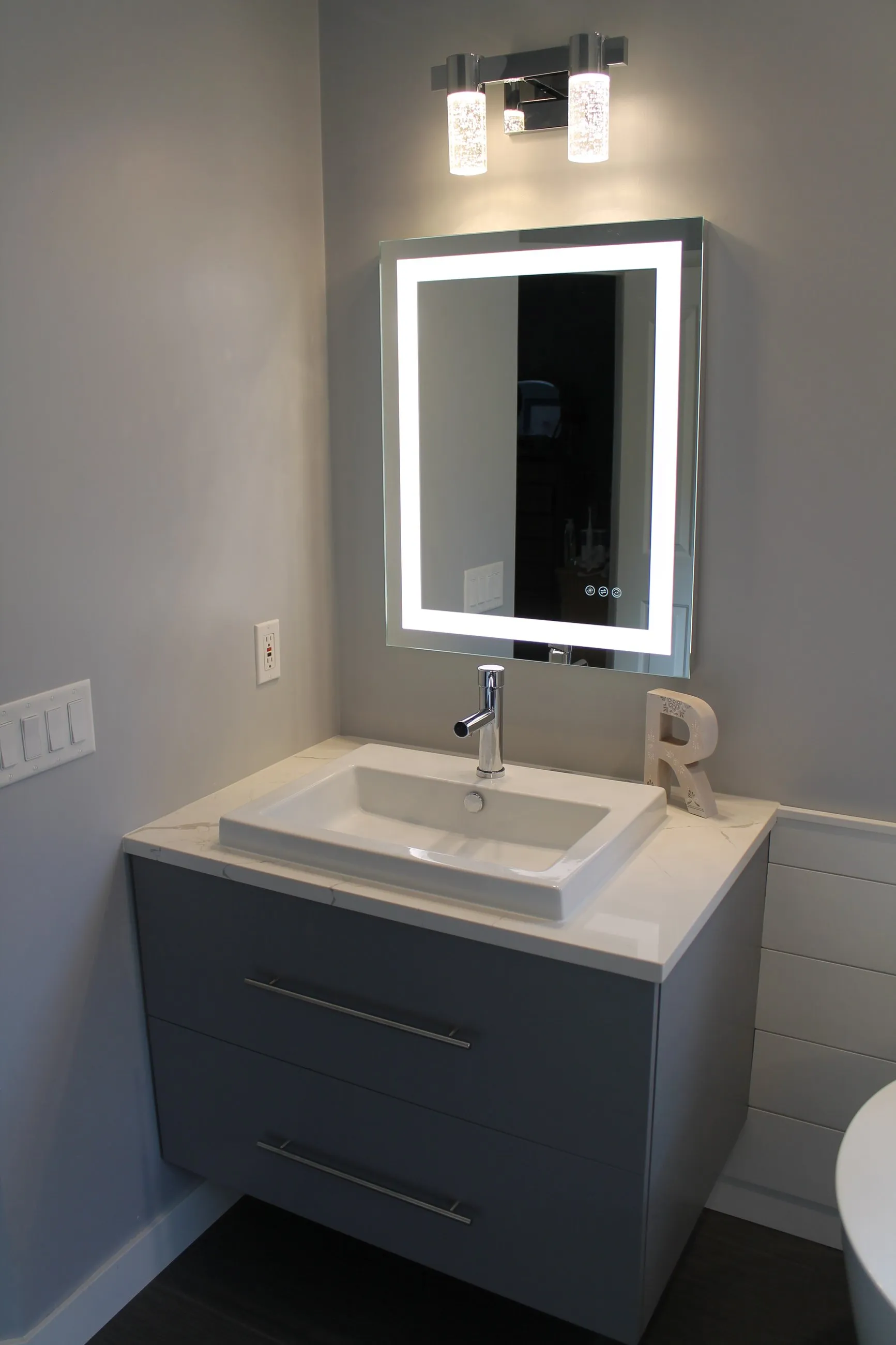 Wall-hung vanity with square vessel sink and lighted mirror