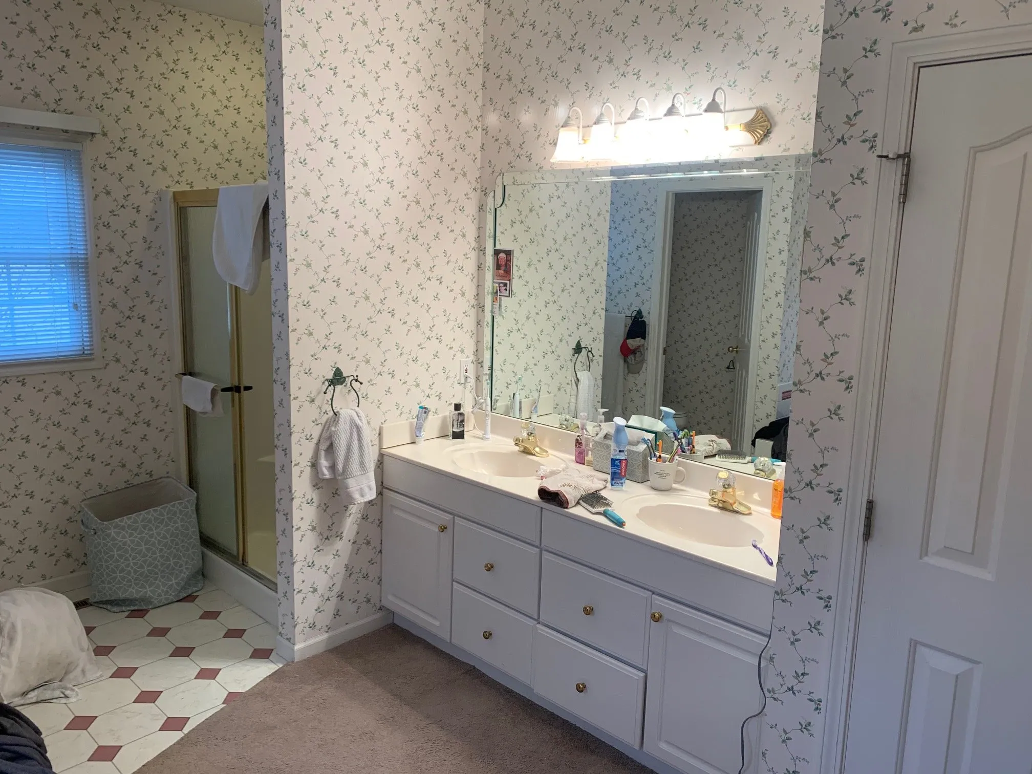 The bathroom before the remodel, with floral wallpaper