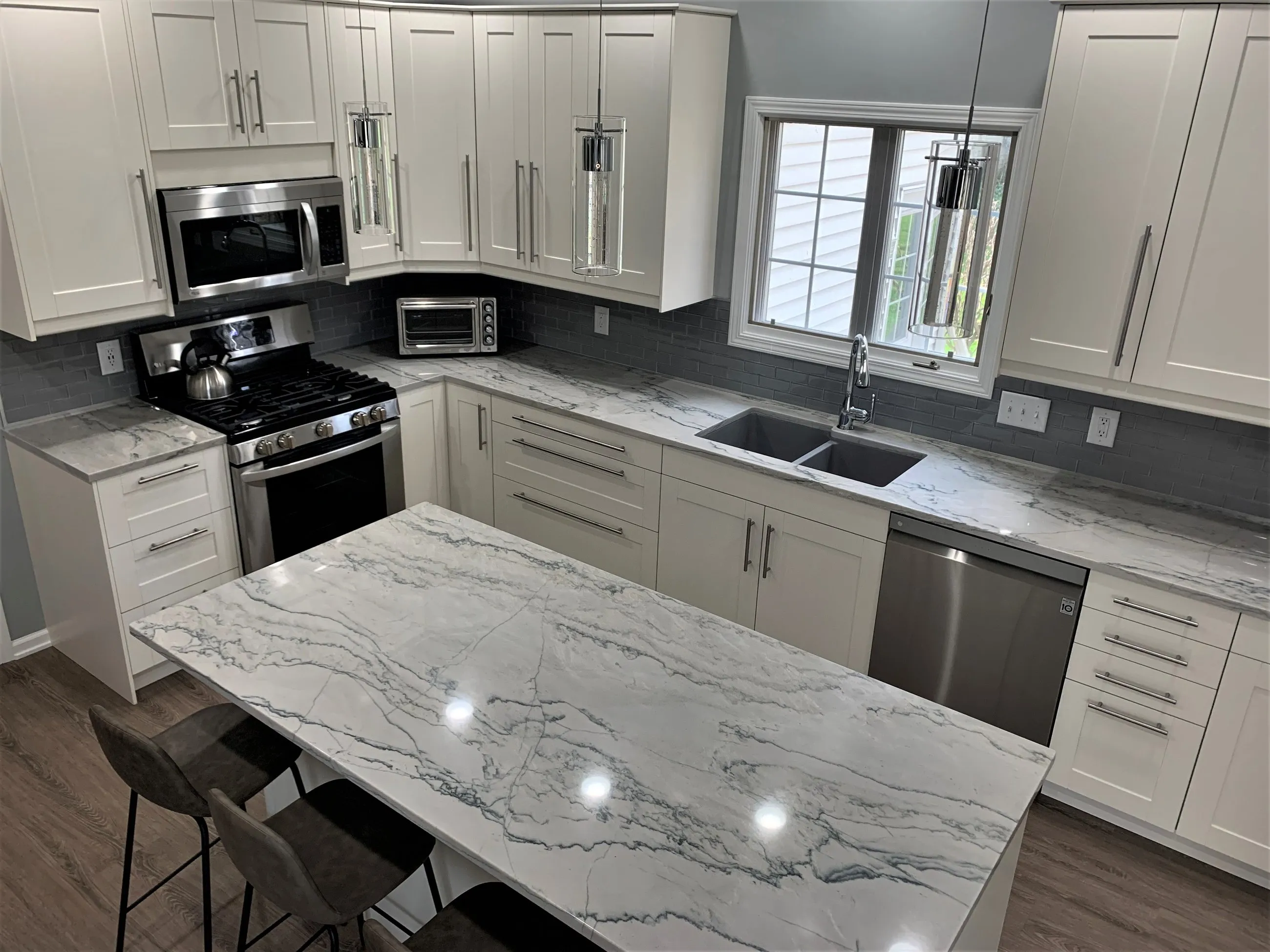 L-shaped run with gas range and grey subway tile