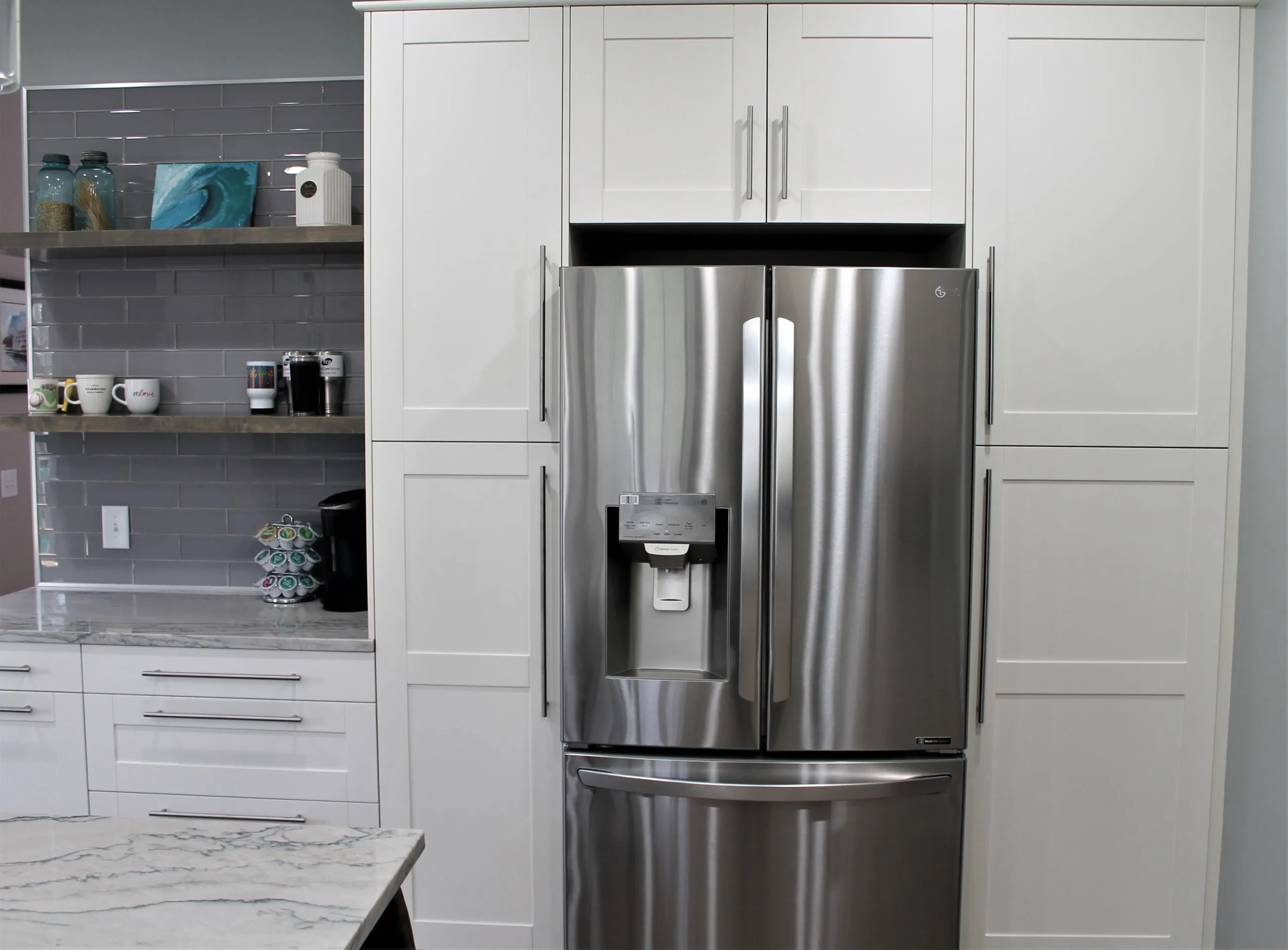 Refrigerator wall with white shaker cabinetry