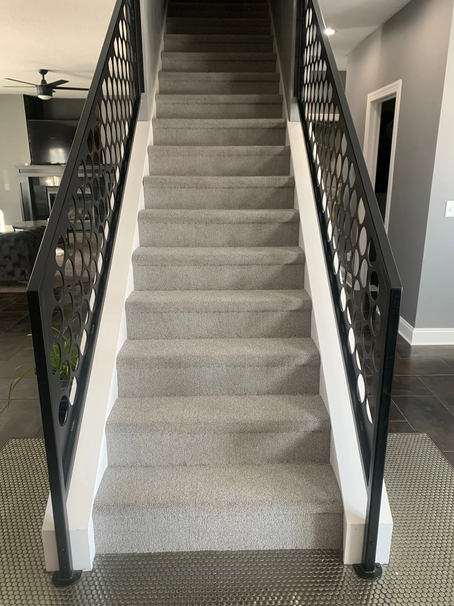 Open-tread staircase with sculptural blackened-steel rails