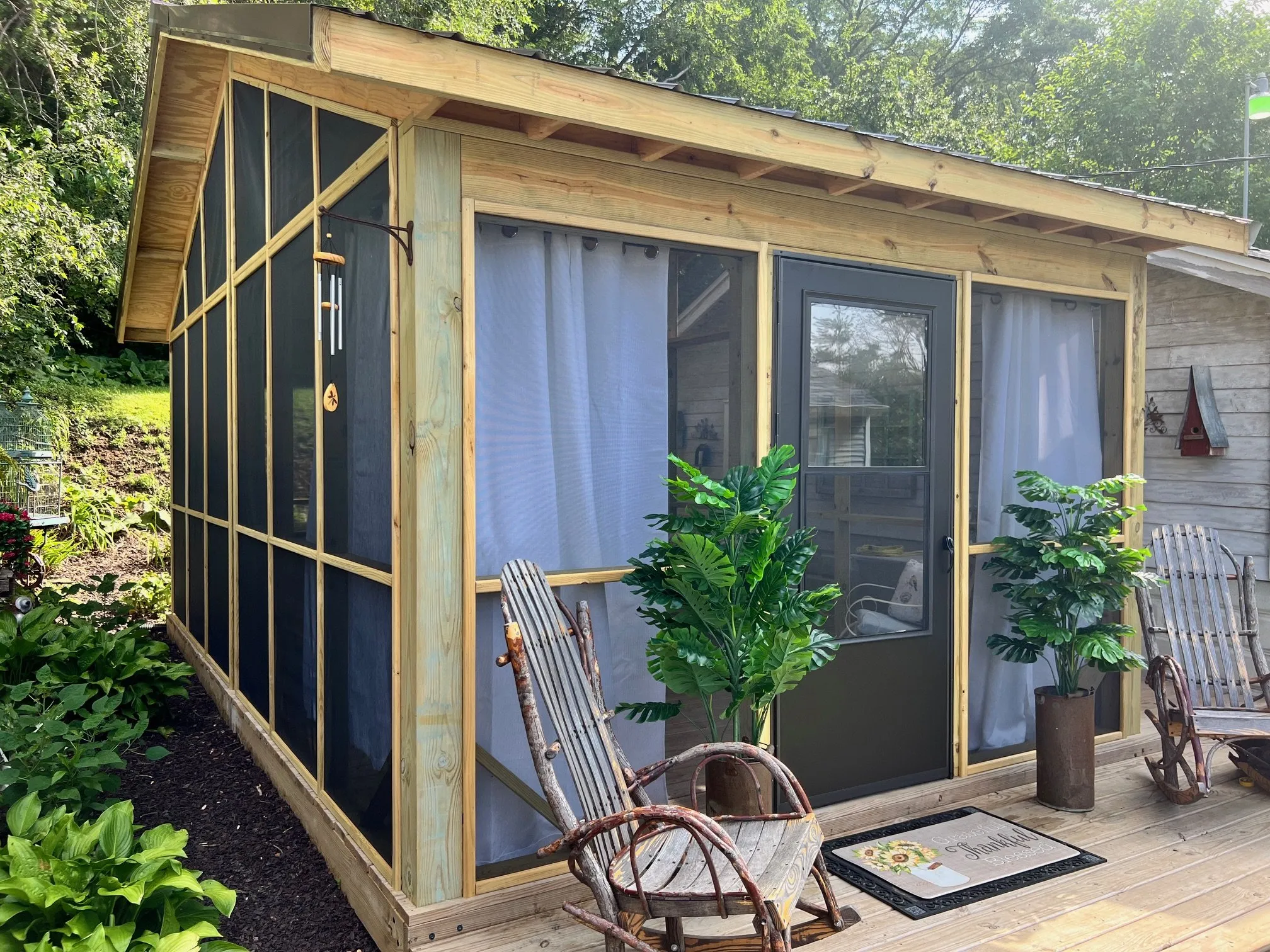 Screened structure surrounded by plantings