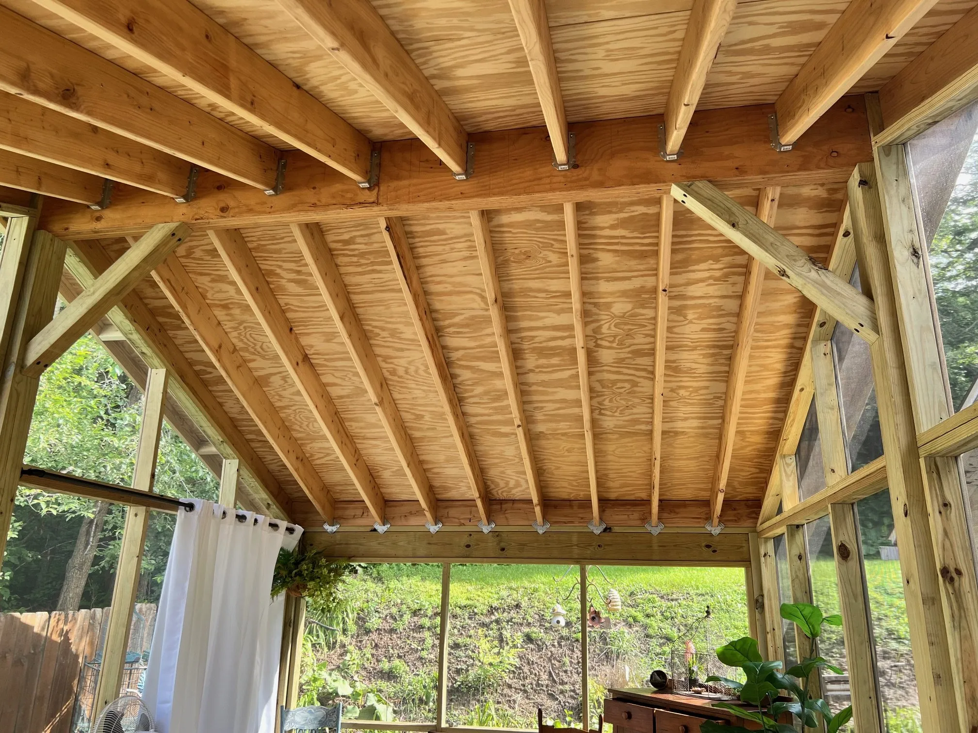 Exposed lumber roof structure over the screened walls