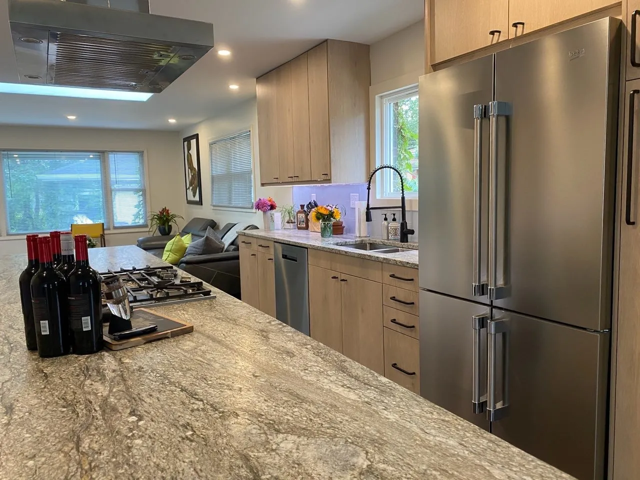 Granite island counter with the four-door refrigerator beyond
