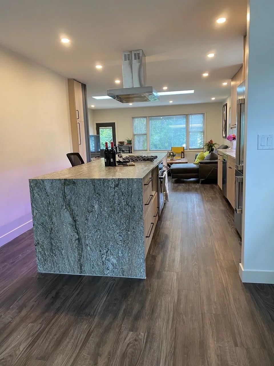 Stone waterfall island anchoring the open main level