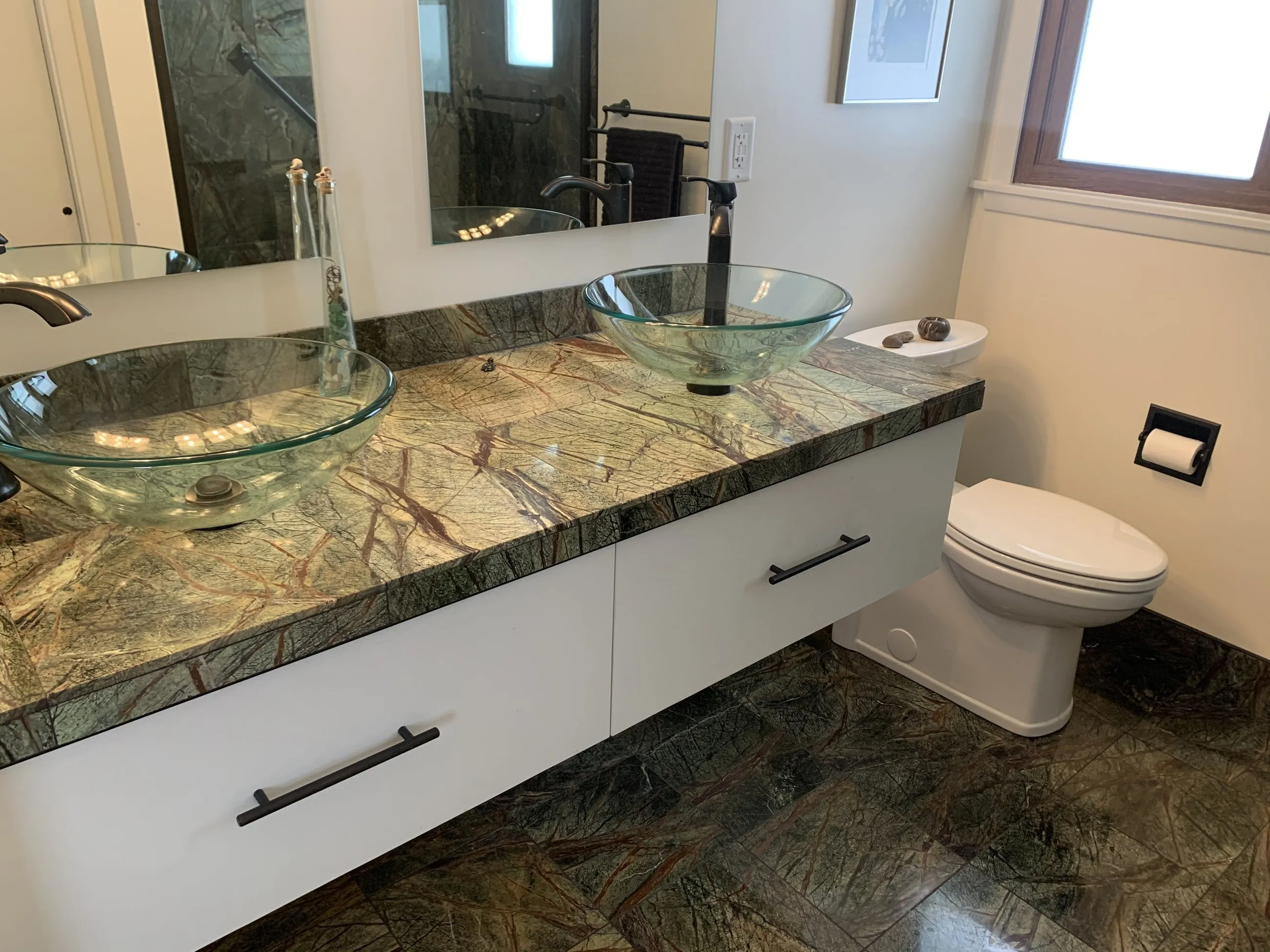 Glass vessel sinks on the marble-topped floating vanity