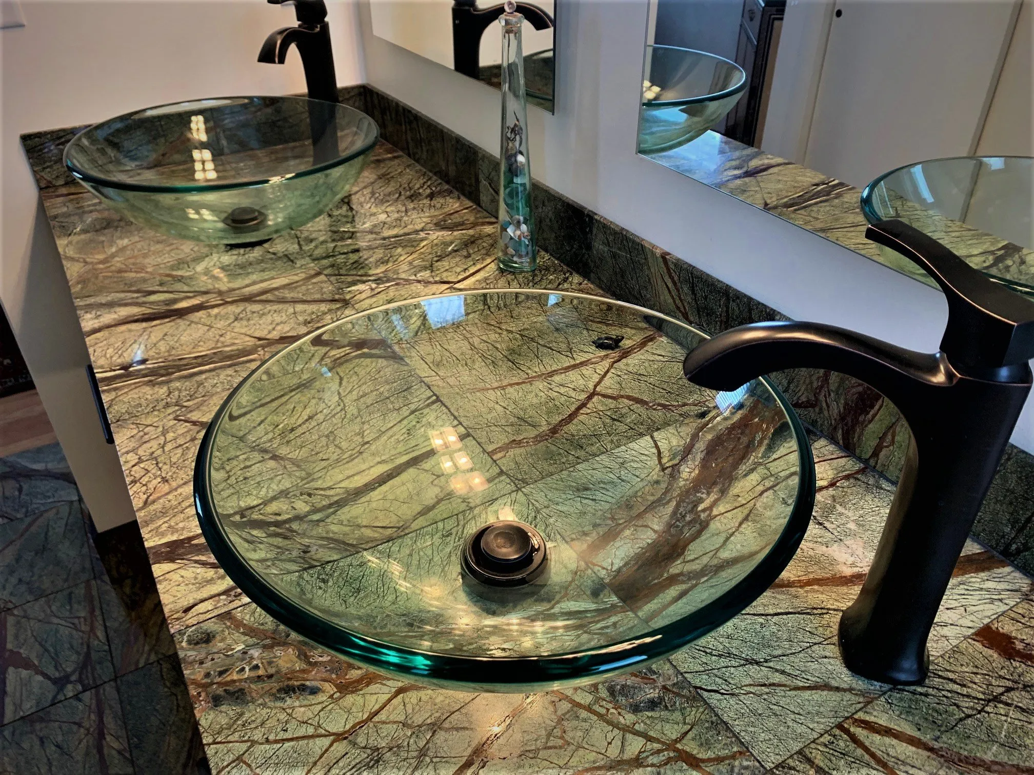 Round glass vessel sink with dark bronze faucet