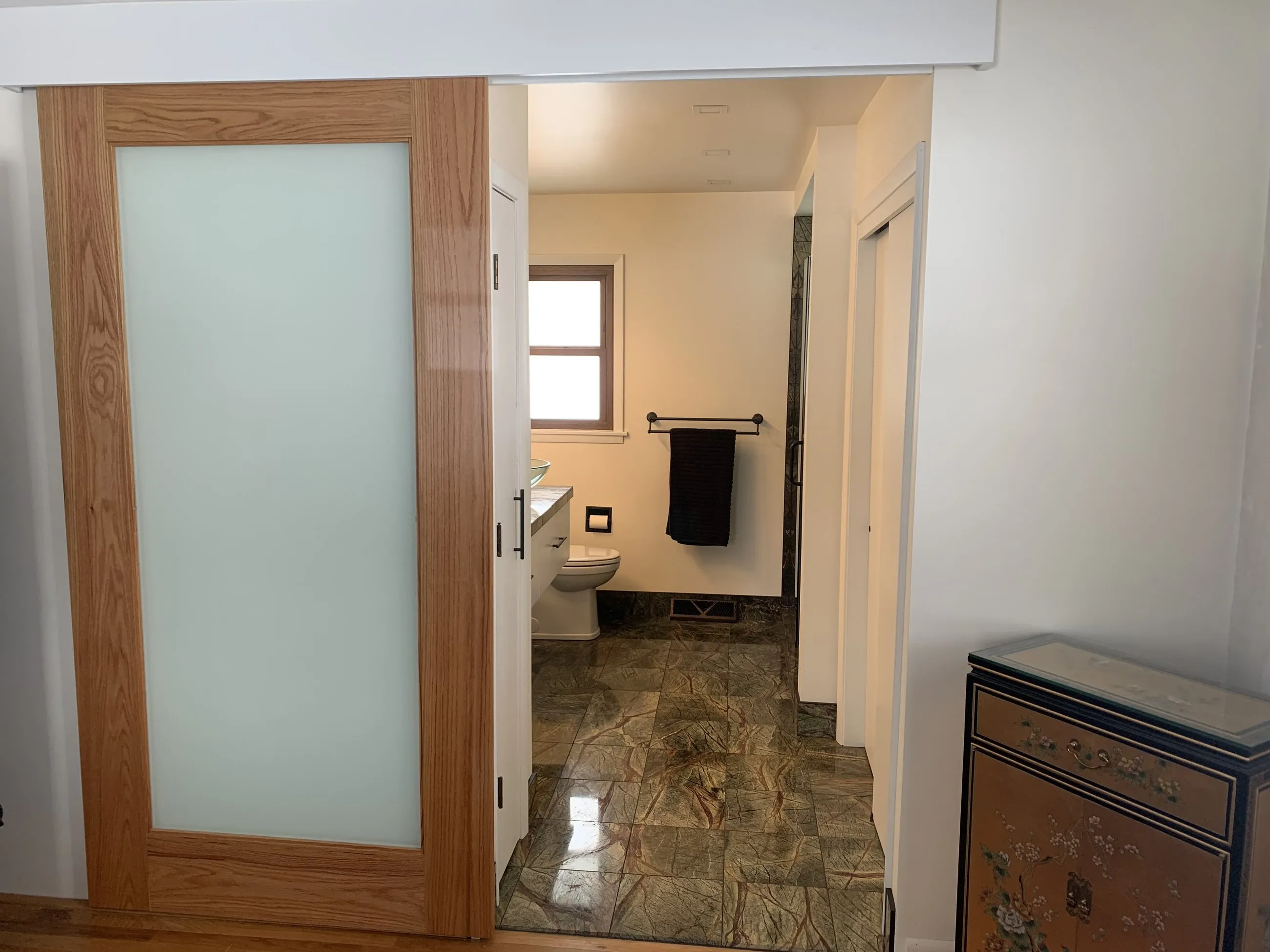 Frosted glass door into the marble-tiled bath