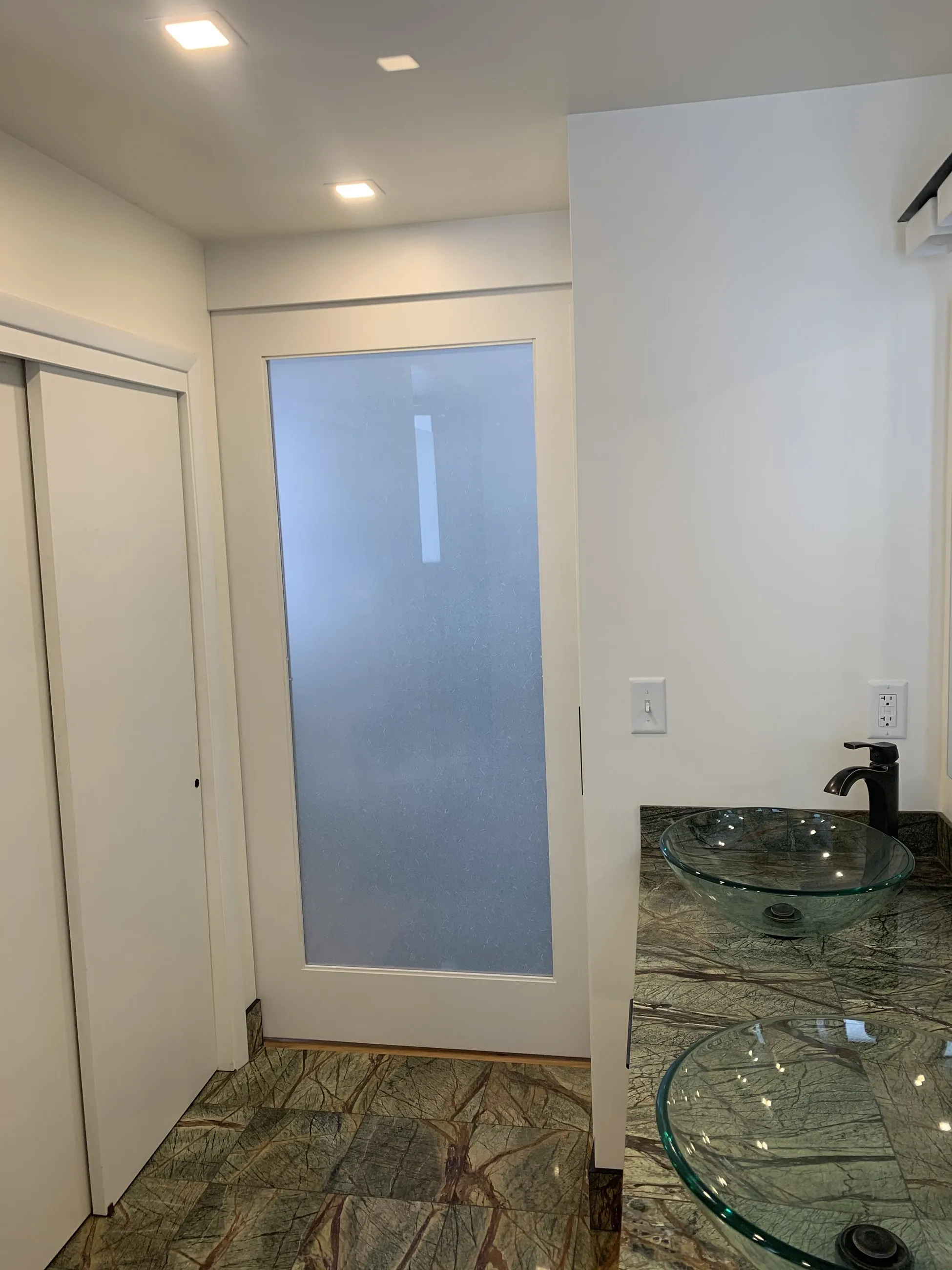Frosted pocket door and rainforest marble floor